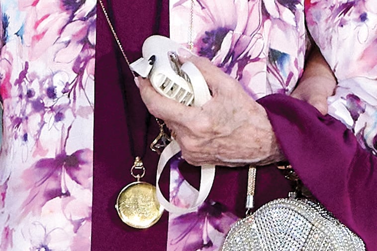 La reina emérita sumó accesorios muy personales: el reloj de bolsillo de su hermana, la princesa Irene de Grecia, que murió en enero pasado, y un miniventilador de mano, que tiene en varios colores, y a veces se lo cuelga como collar