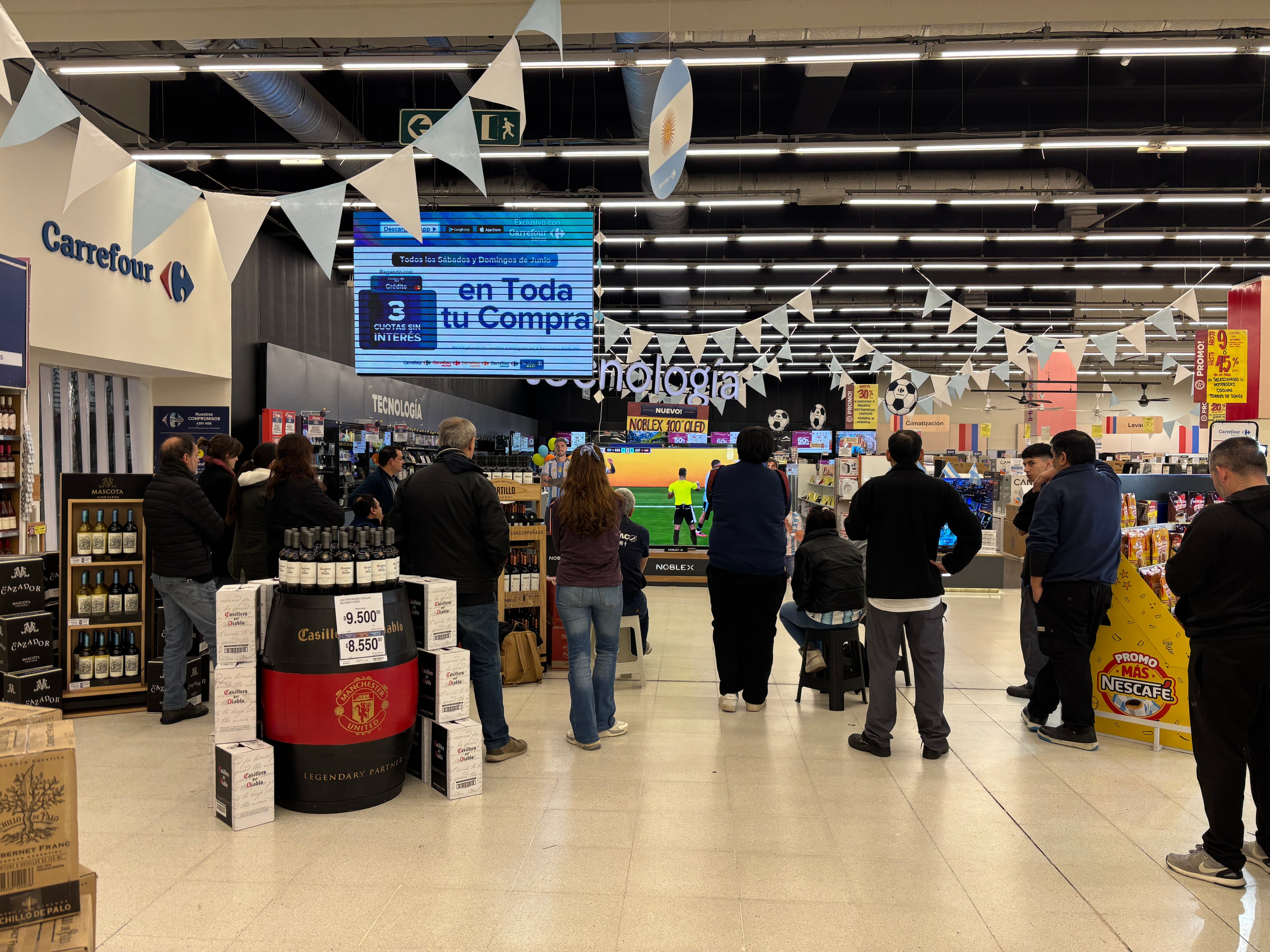 En el supermercado nadie quiere perderse un detalle del partido