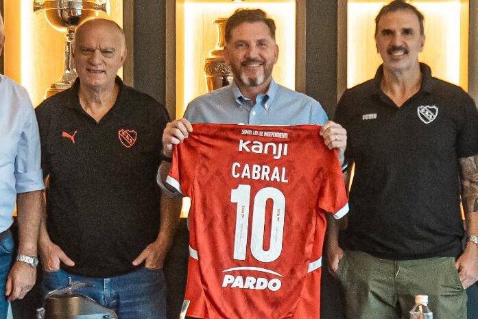 Alejandro Domínguez, titular de la Conmebol, muestra la camiseta de Independiente junto al presidente de Independiente, Néstor Grindetti, y Daniel Seoane, secretario del club, en una imagen de abril