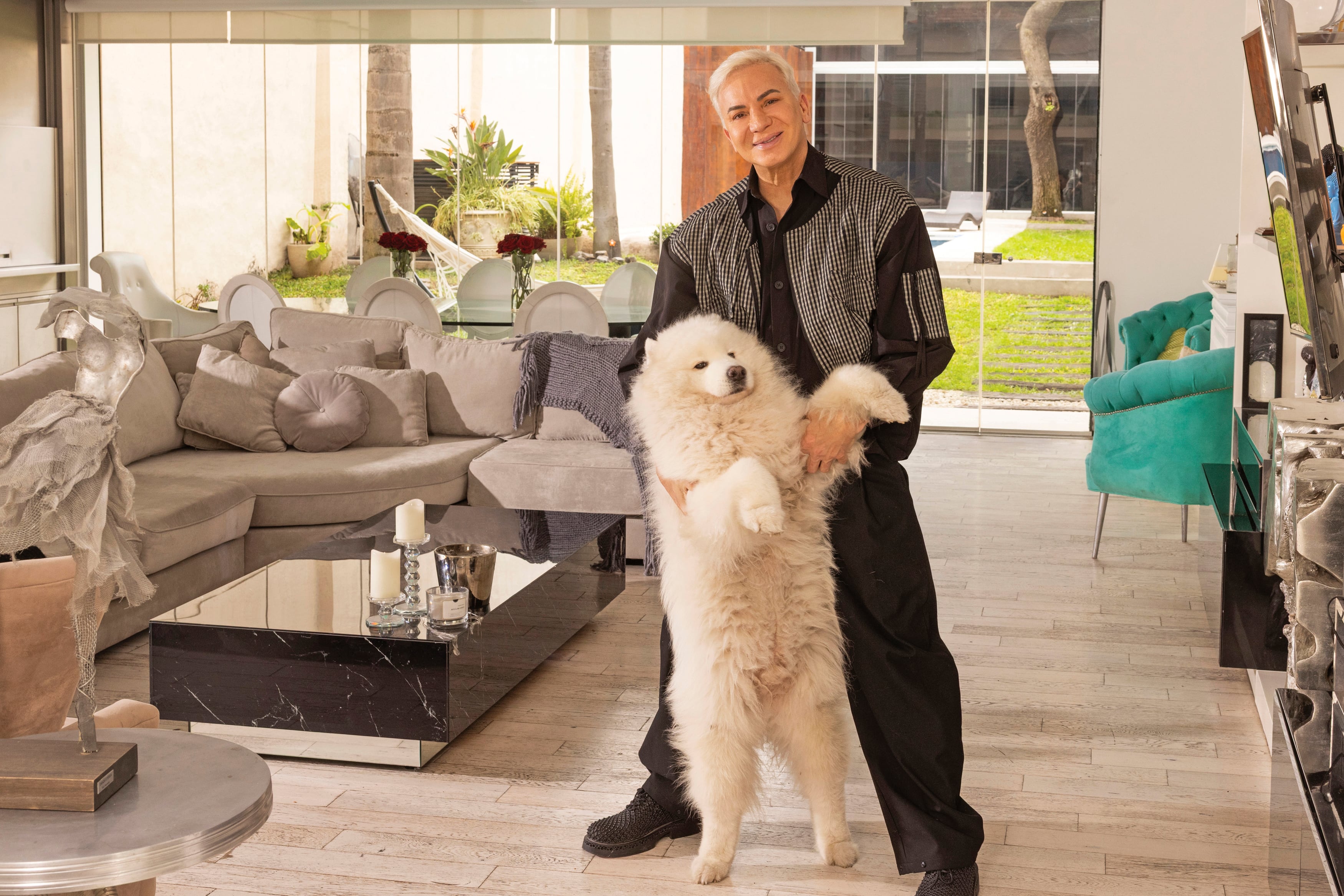 Flavio posa con su perro. De fondo, se ve el jardín de la casa. En agosto estrena