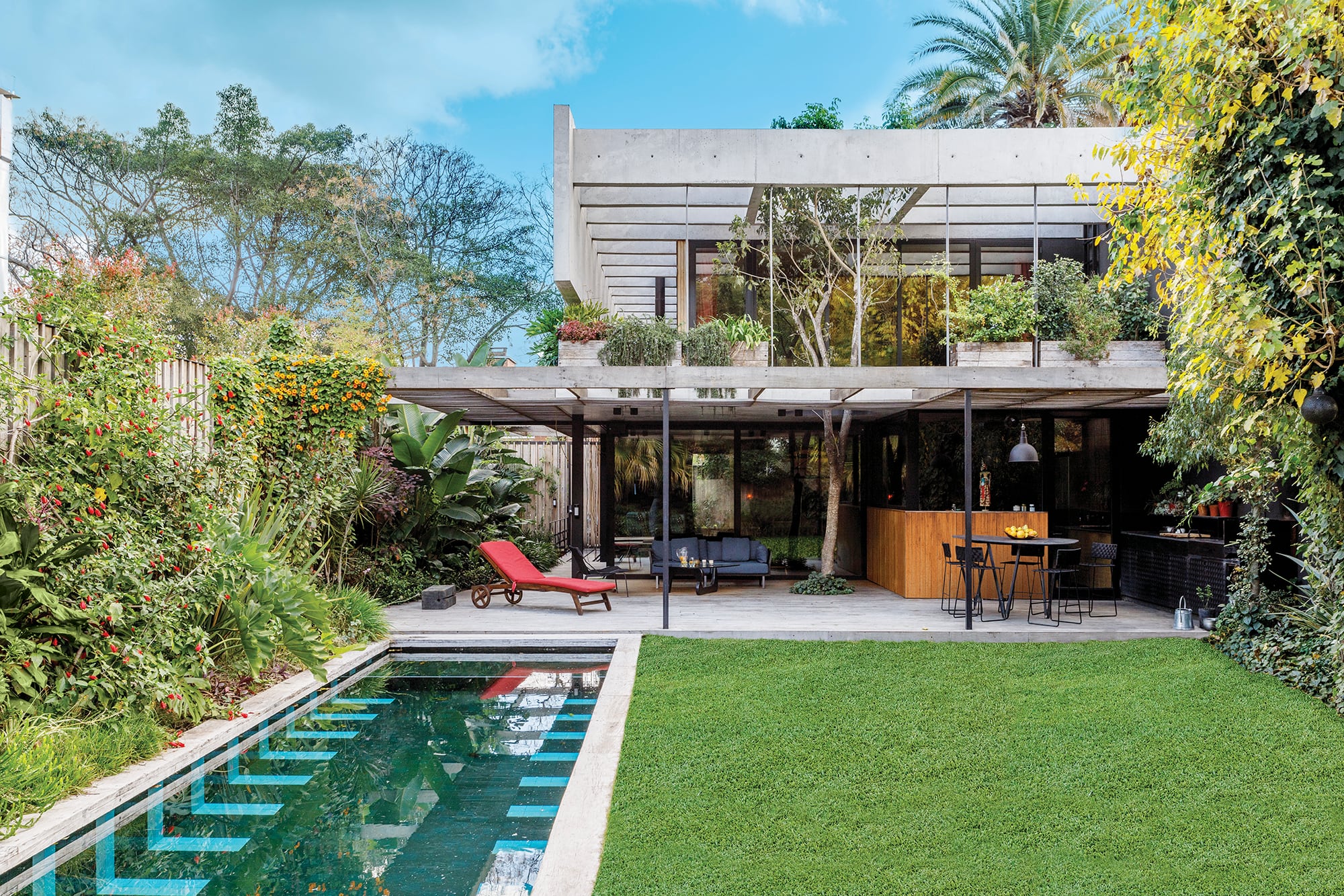 En sentido perpendicular a la galería, la pileta se diseñó con revestimientos artesanales de 10x10cm en dos colores: verde oscuro para el fondo y patrones geométricos turquesas que evocan los andariveles de las de competición.