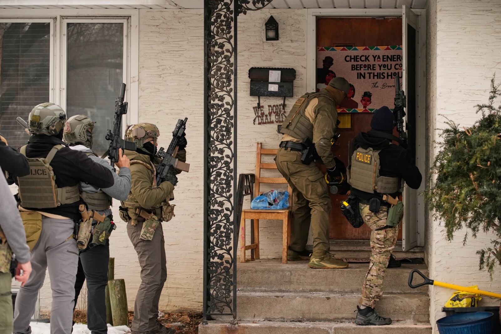 Un agente federal de inmigración utiliza un ariete para derribar una puerta antes de realizar un arresto, el domingo 11 de enero de 2026, en Minneapolis