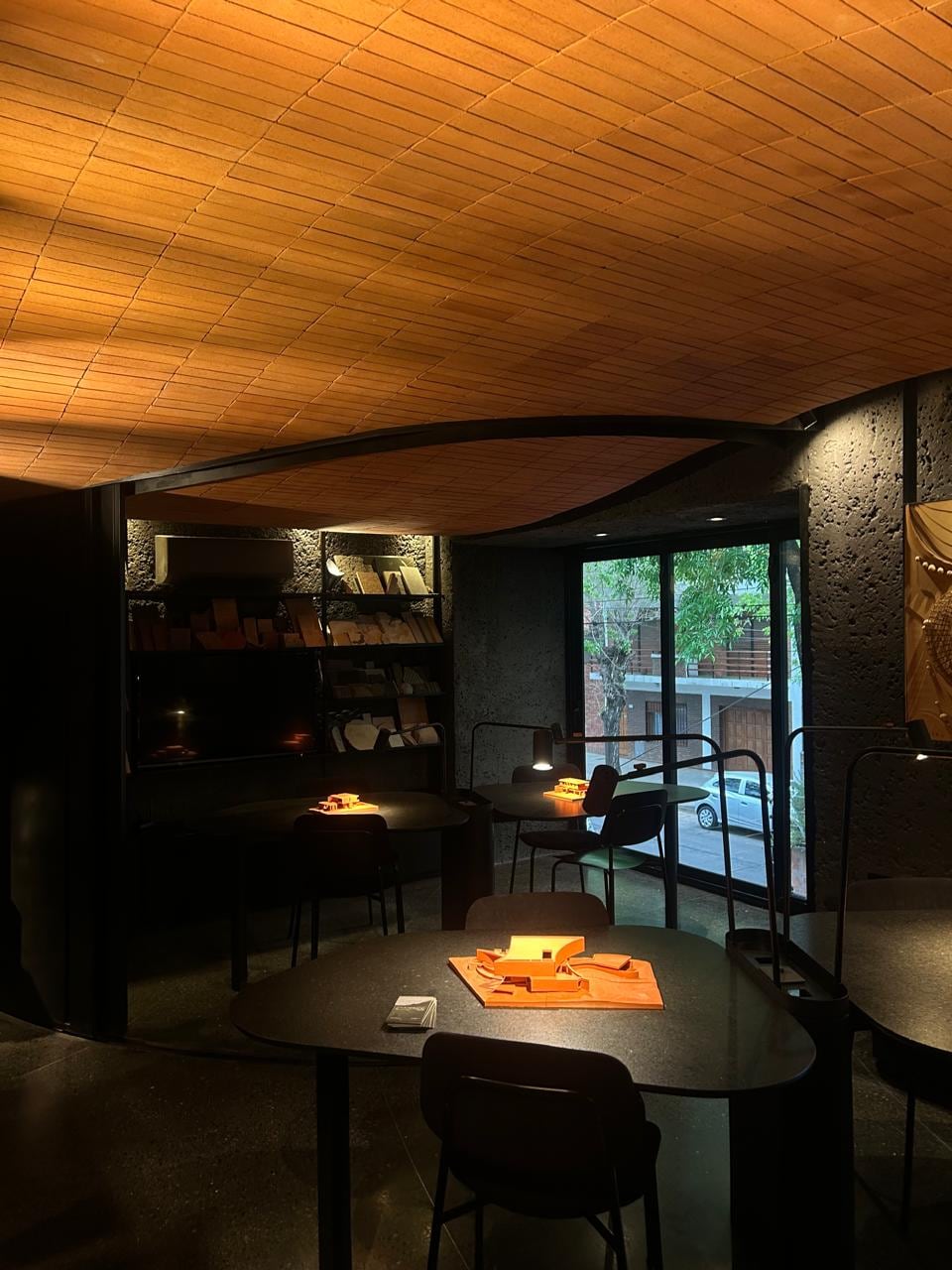 El estudio se trata de un espacio de superficie acotada, organizado con mesas de trabajo y estanterías cargadas de muestras y maquetas