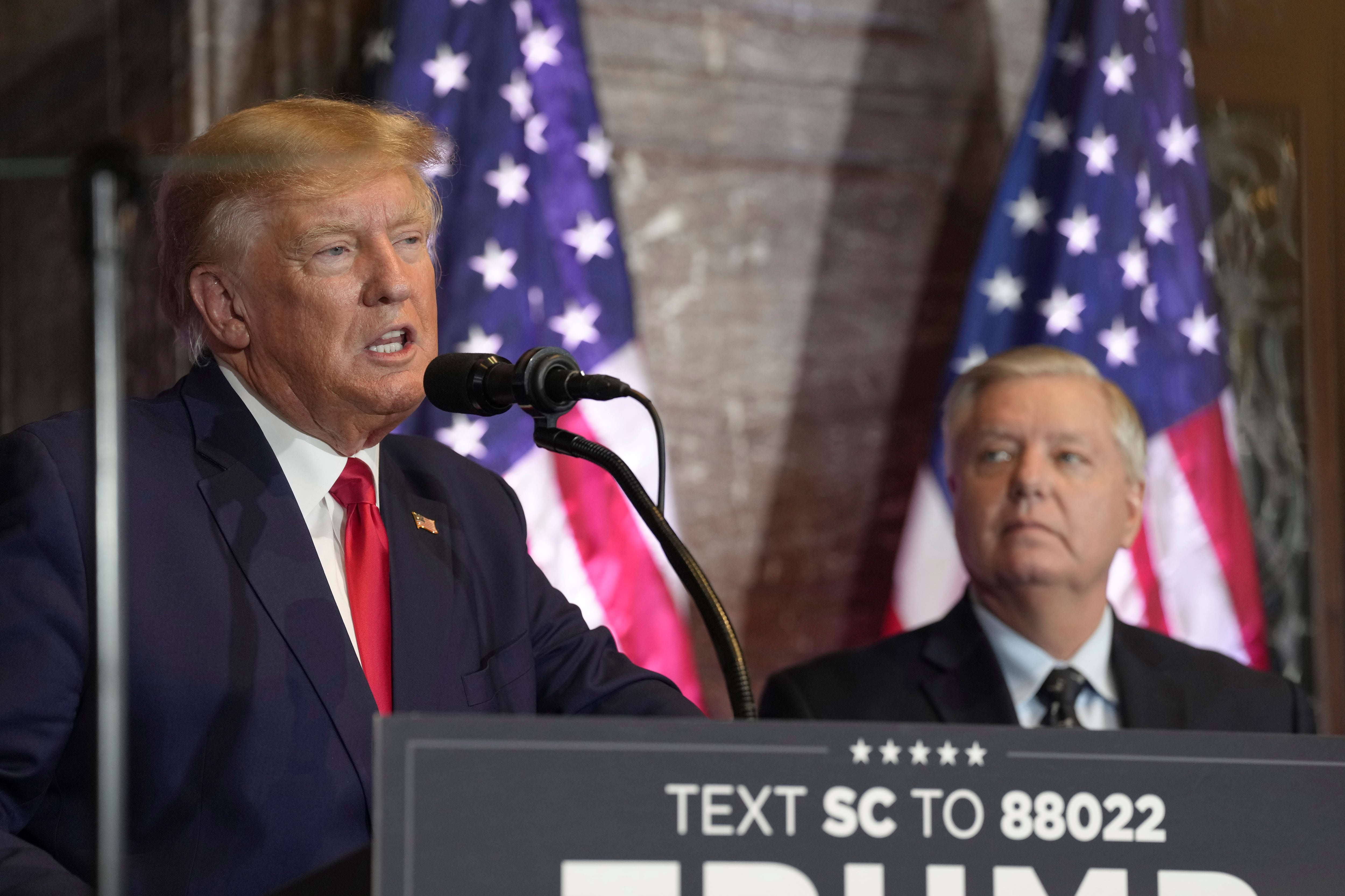 El presidente Donald Trump habla en un acto de campaña mientras el senador republicano Lindsey Graham lo observa