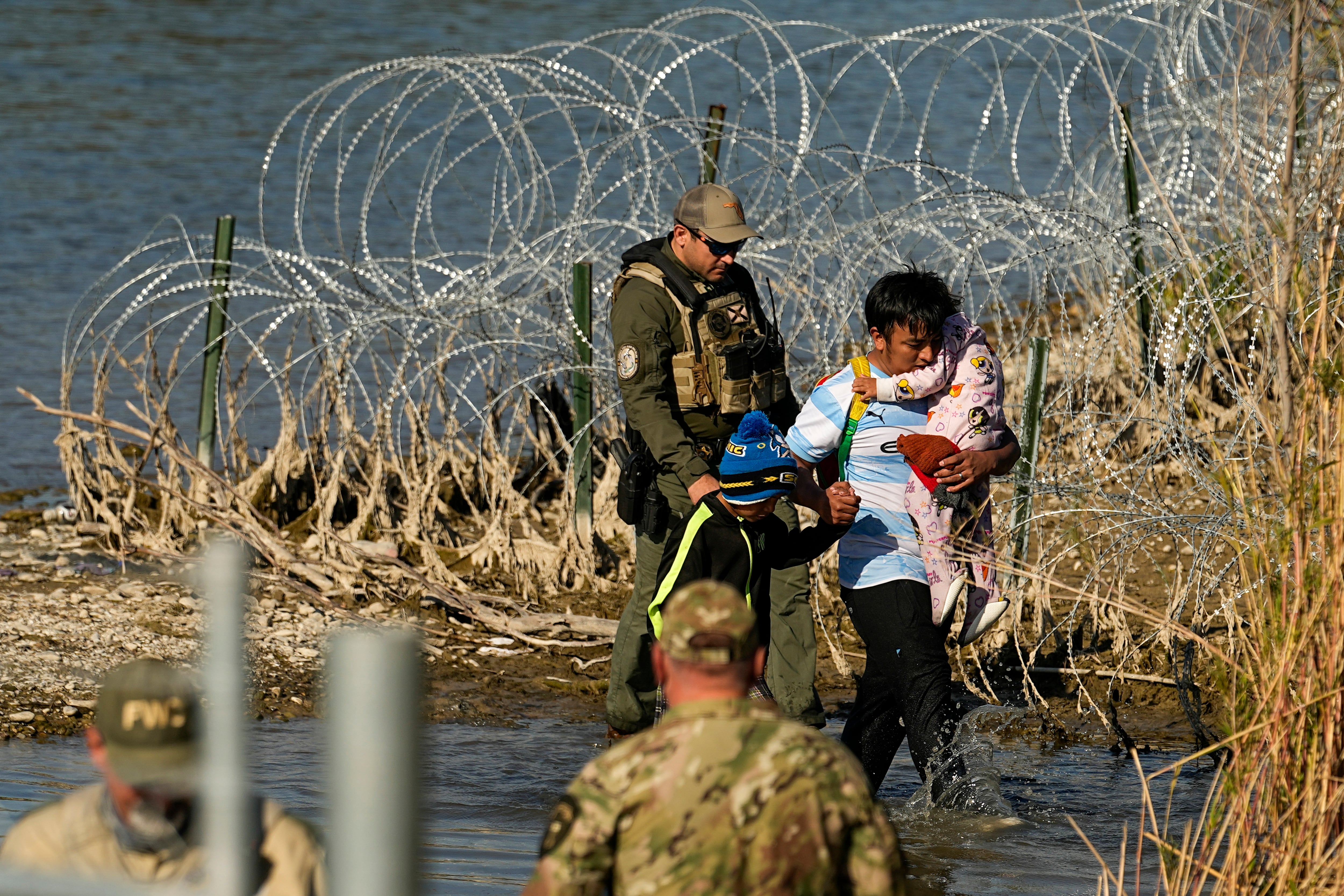 ARCHIVO - Un grupo de migrantes es detenido por oficiales en la frontera entre Texas y México el 3 de enero de 2024, en Eagle Pass, Texas. (AP Foto/Eric Gay, Archivo)