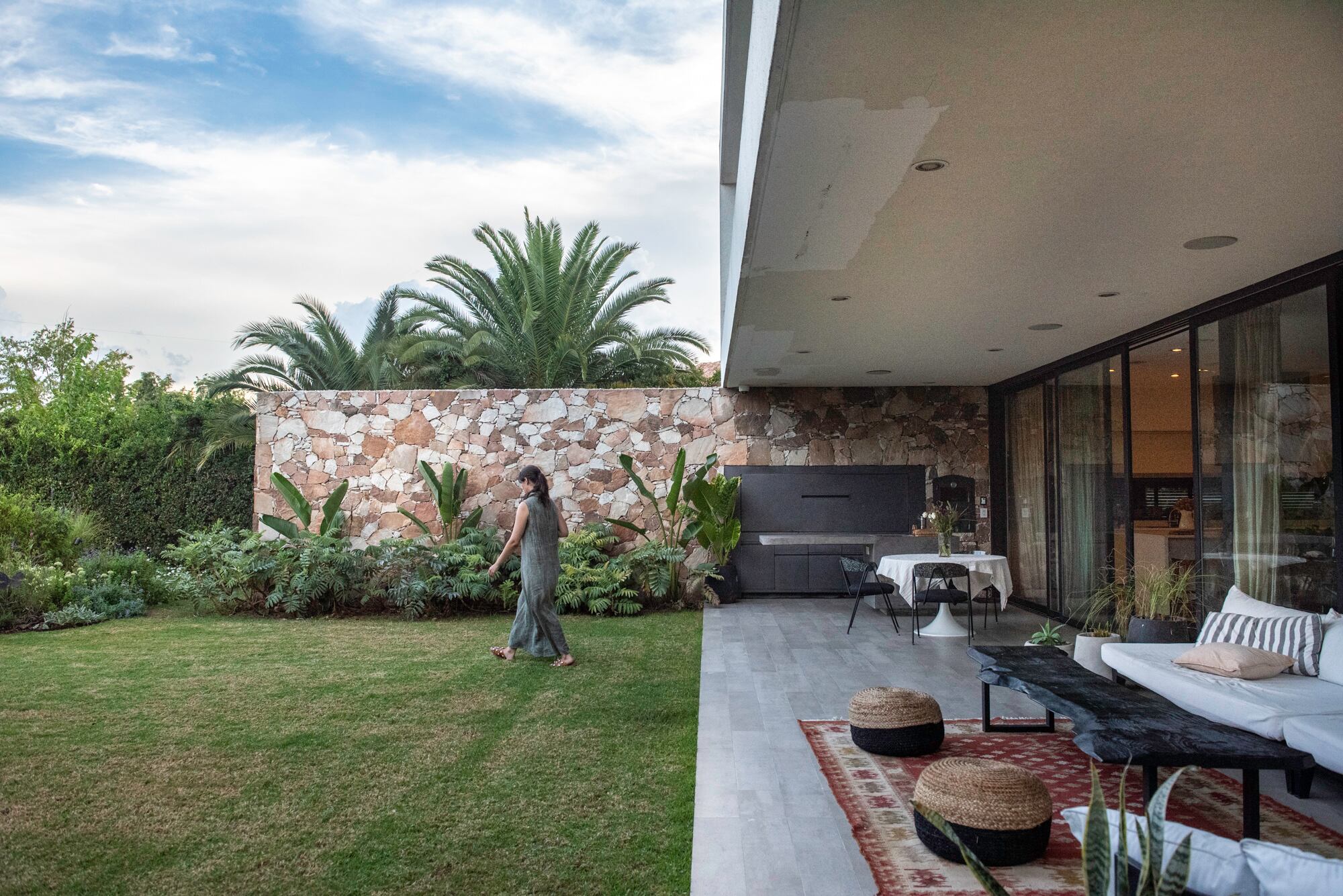 La piedra rojiza es protagonista en la arquitectura y está muy bien acompañada por una plantación que la resalta.