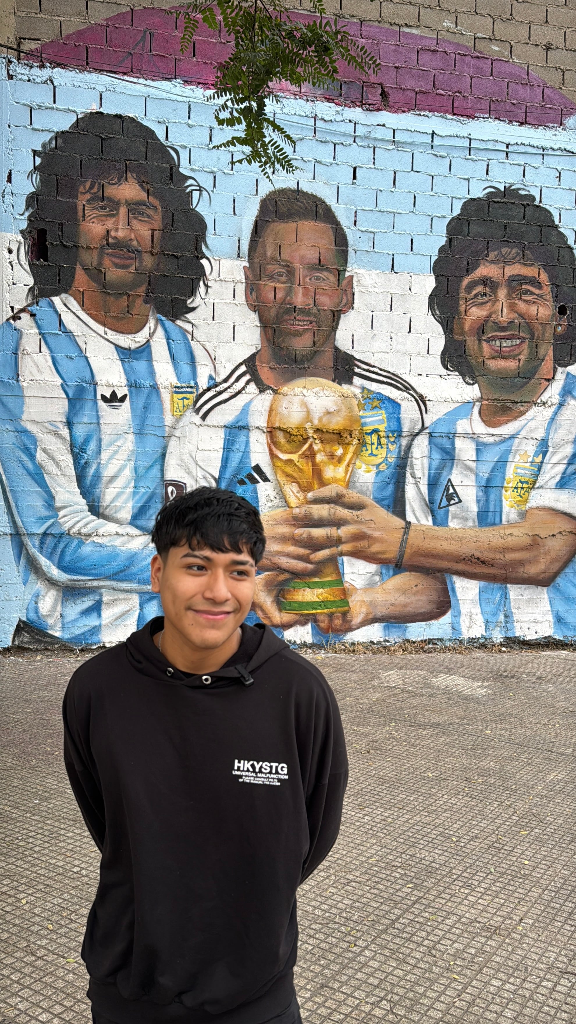 Alexis Gaspar, en el barrio Mugica, cuenta su pronóstico para la final teniendo de fondo a tres grandes del fútbol argentino