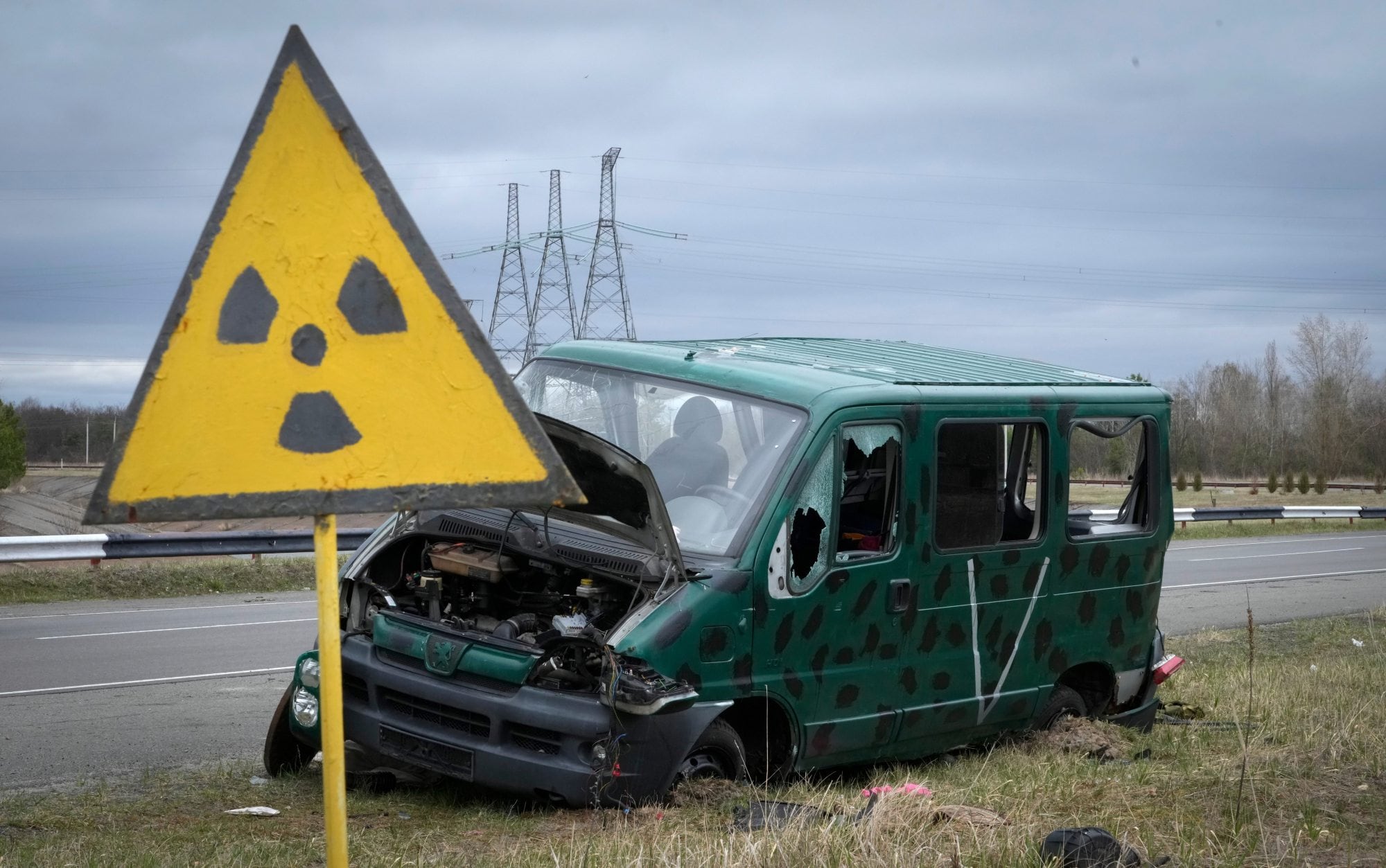 Un cartel de advertencia de radiación sigue en pie junto a los restos de una camioneta de militares rusos cerca de Chernobyl, en 2022