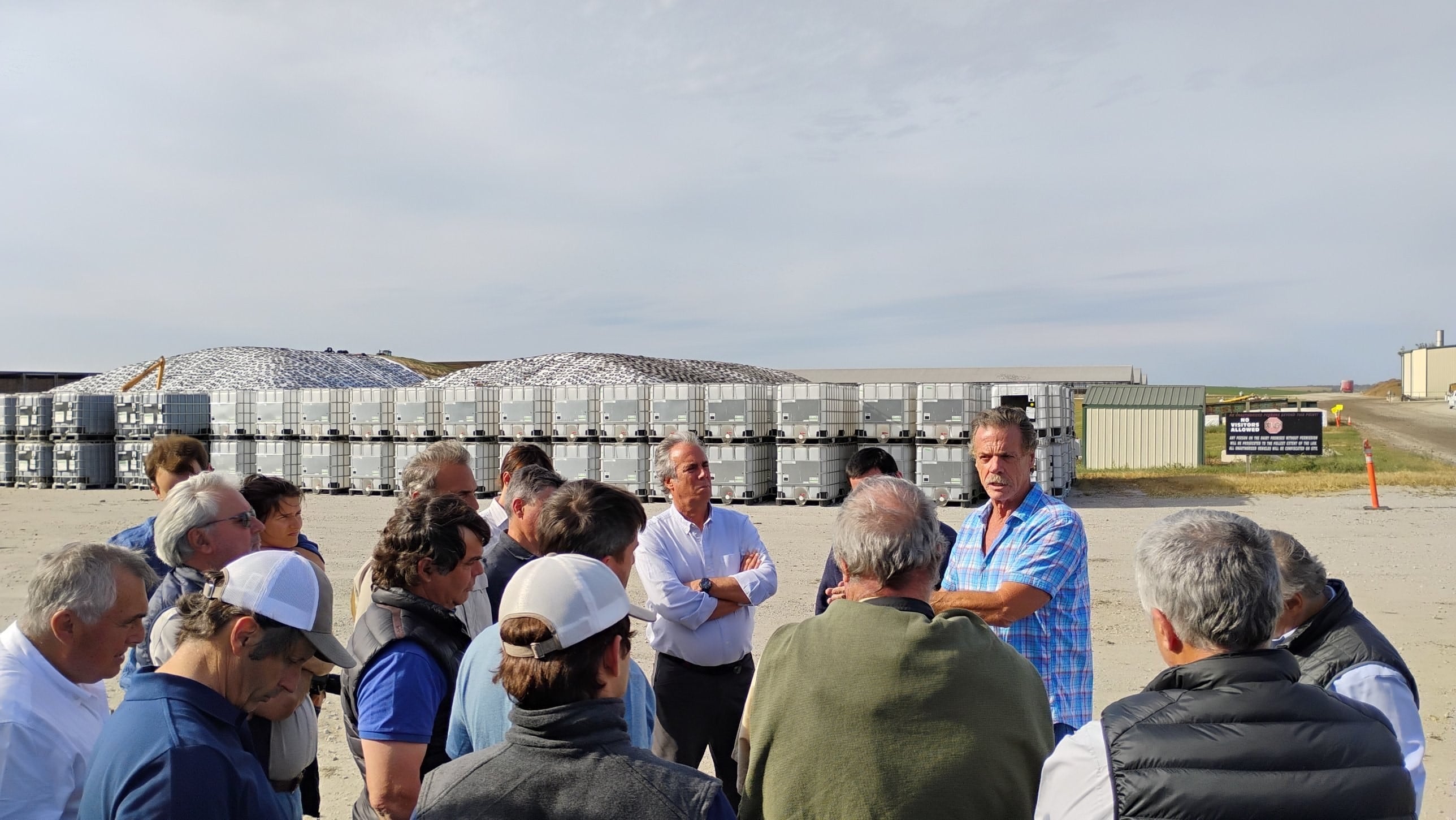 Mike McCloskey (camisa a cuadros) explica el sistema al grupo de la Fundación Producir Conservando. Detrás, los silos de maíz y los contenedores de la planta de tratamiento