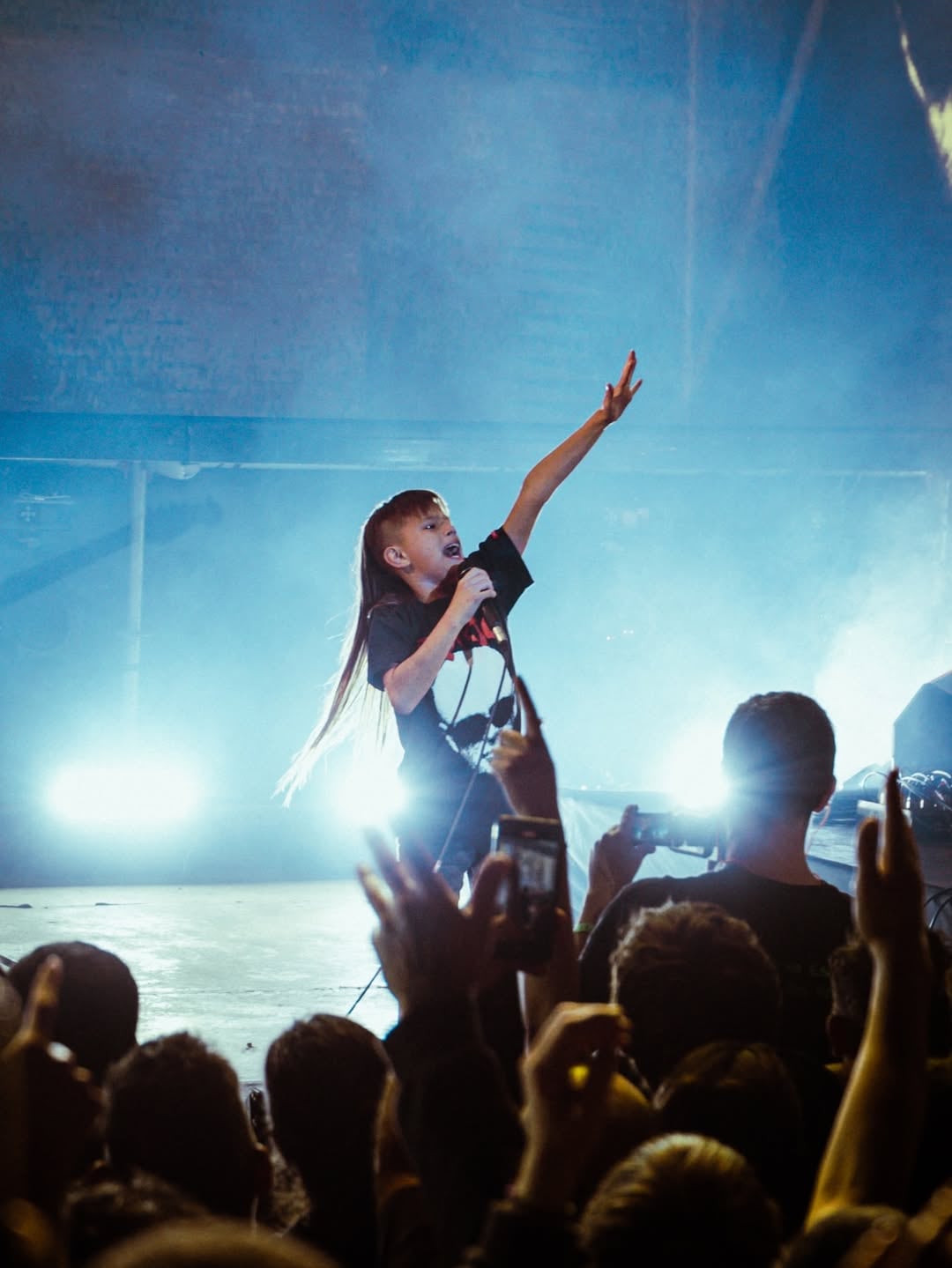 Agustín arriba del escenario mientras interpreta