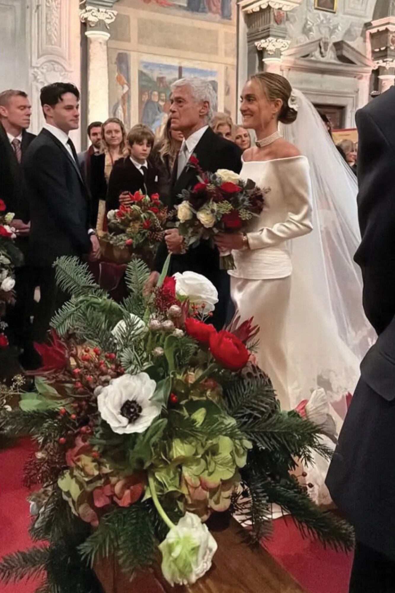 La novia entra del brazo de John Frieda –conocido como el “peluquero de la realeza”–, el hombre con el que su mamá, Frances Avery Howe, se casó tras la muerte de Giovannino Agneli y quien la crio desde muy chica