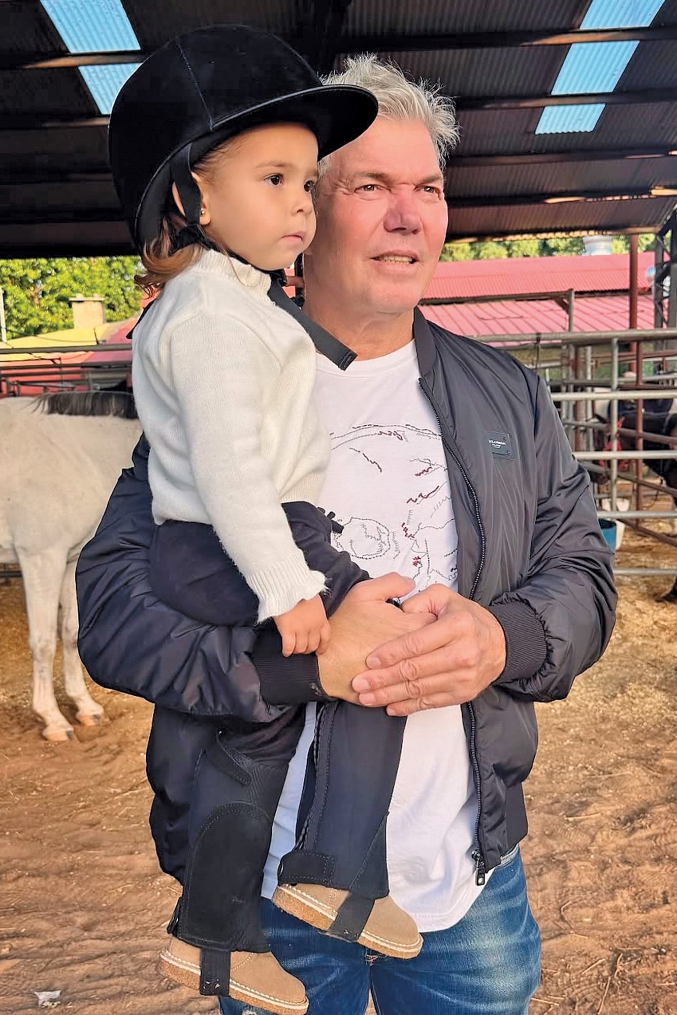 La niña en brazos de su padre durante sus primeras clases
de equitación