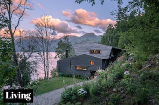 Hecha en madera, una casa de 11 metros de altura encontró su lugar entre la montaña y el lago