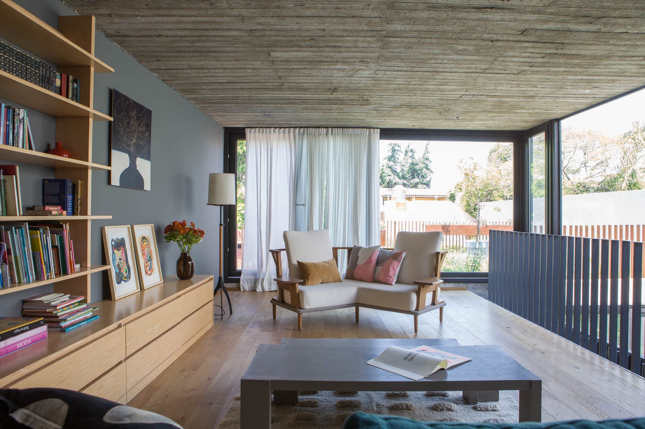Biblioteca (Gabriel García Cabrera), Mesa de arrime (Eugenio Aguirre). Alfombra (Elementos Argentinos). Sobre el sillón color manteca, almohadones estampados y lisos (Pezkoi Deco)