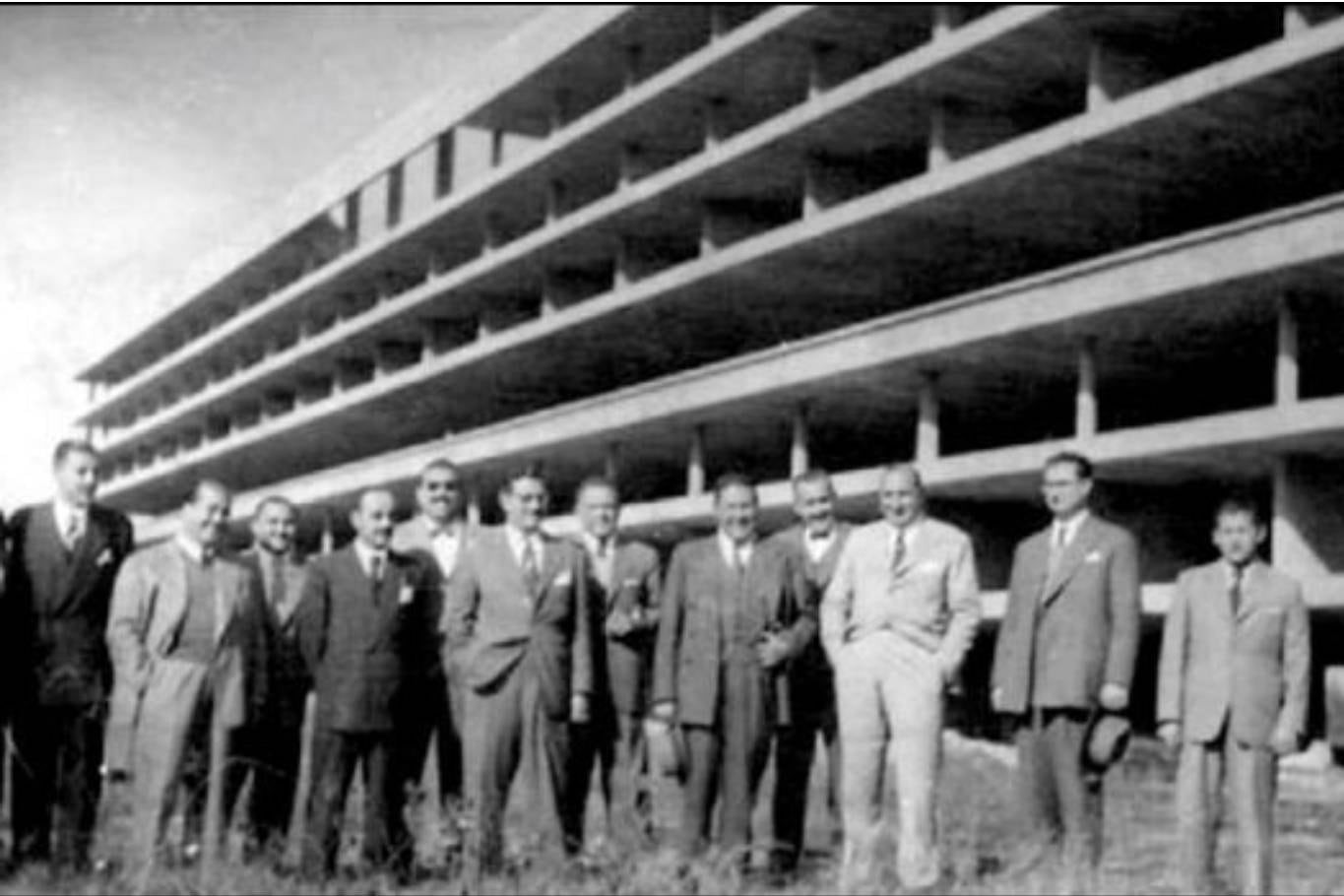 Autoridades de la UNT, arquitectos e ingenieros que participaron en el diseño de la Ciudad Universitaria posan frente al que sería el futuro bloque de residencia para estudiantes
