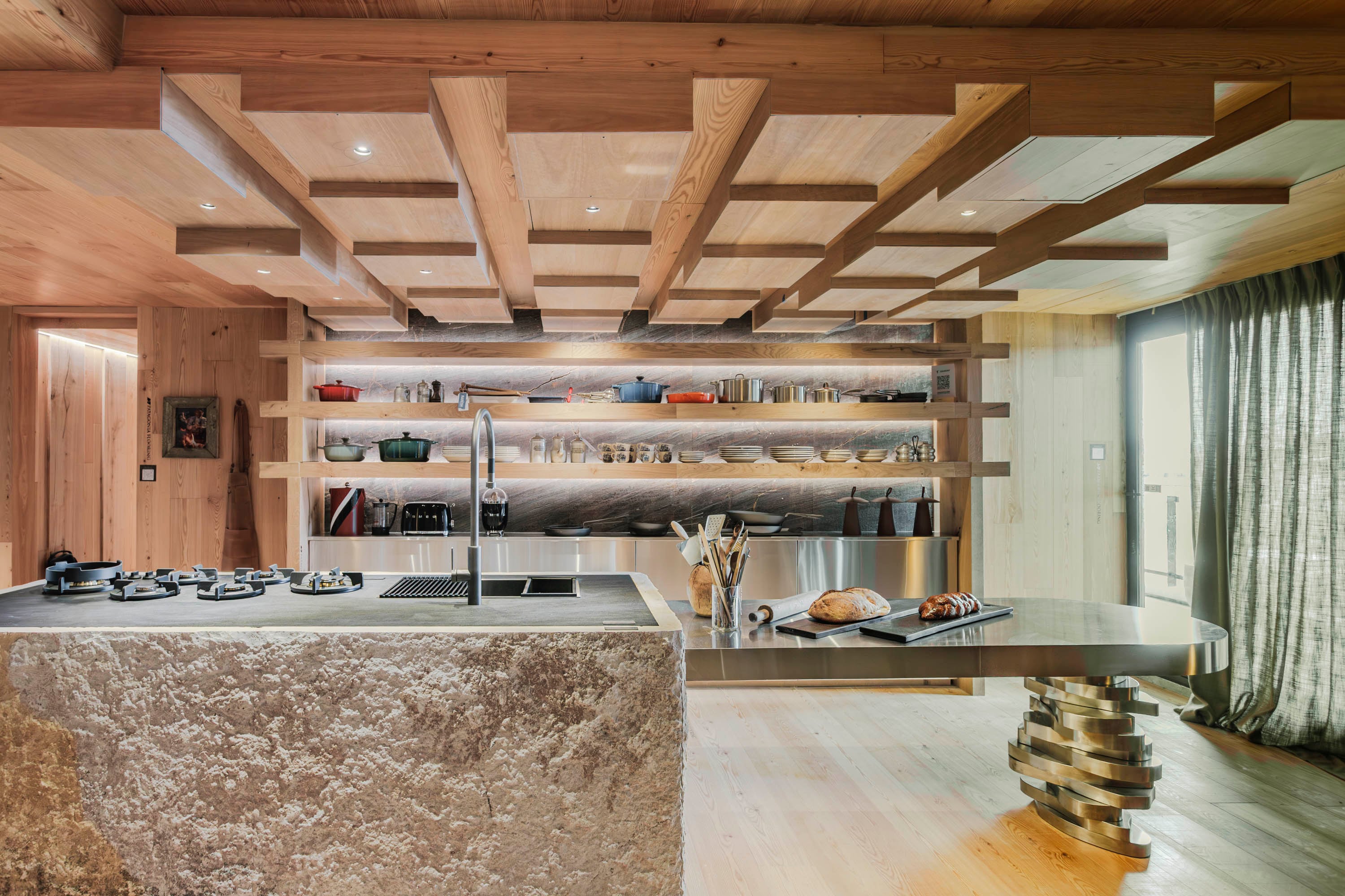 Cielo raso suspendido en roble nativo (Patagonia Flooring) con luces empotradas sin marco (IDEA Iluminación). Isla revestida en Neolith 'Basalt Black' (De Stefano). Estantería de roble (Patagonia Flooring) con vajilla (Kiluga). Cortinas de lino de Hunter Douglas (Snob).