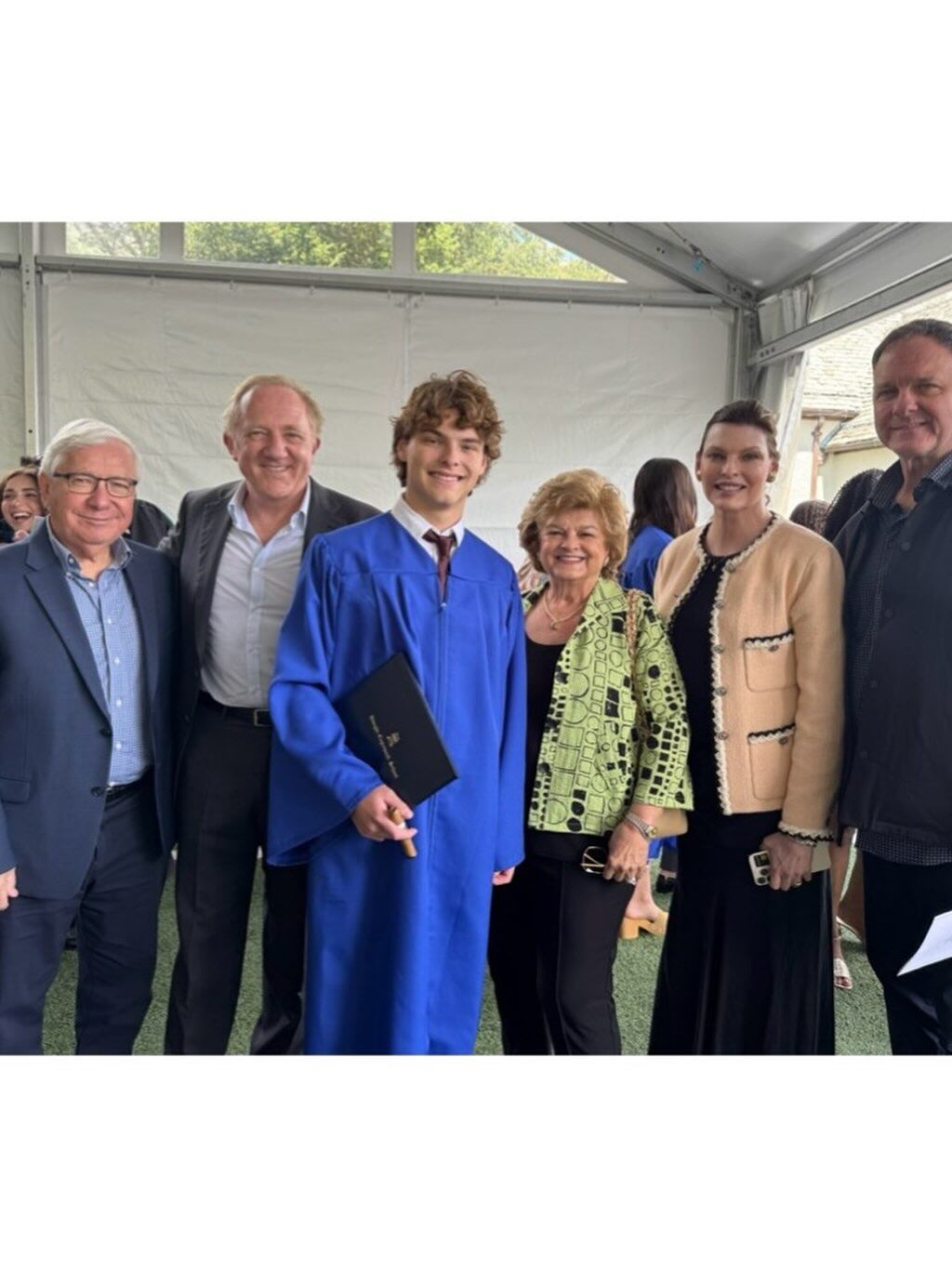 Agustin James con la toga de graduado, junto a sus padres, Linda Evangelista y Francois-Henri Pinault