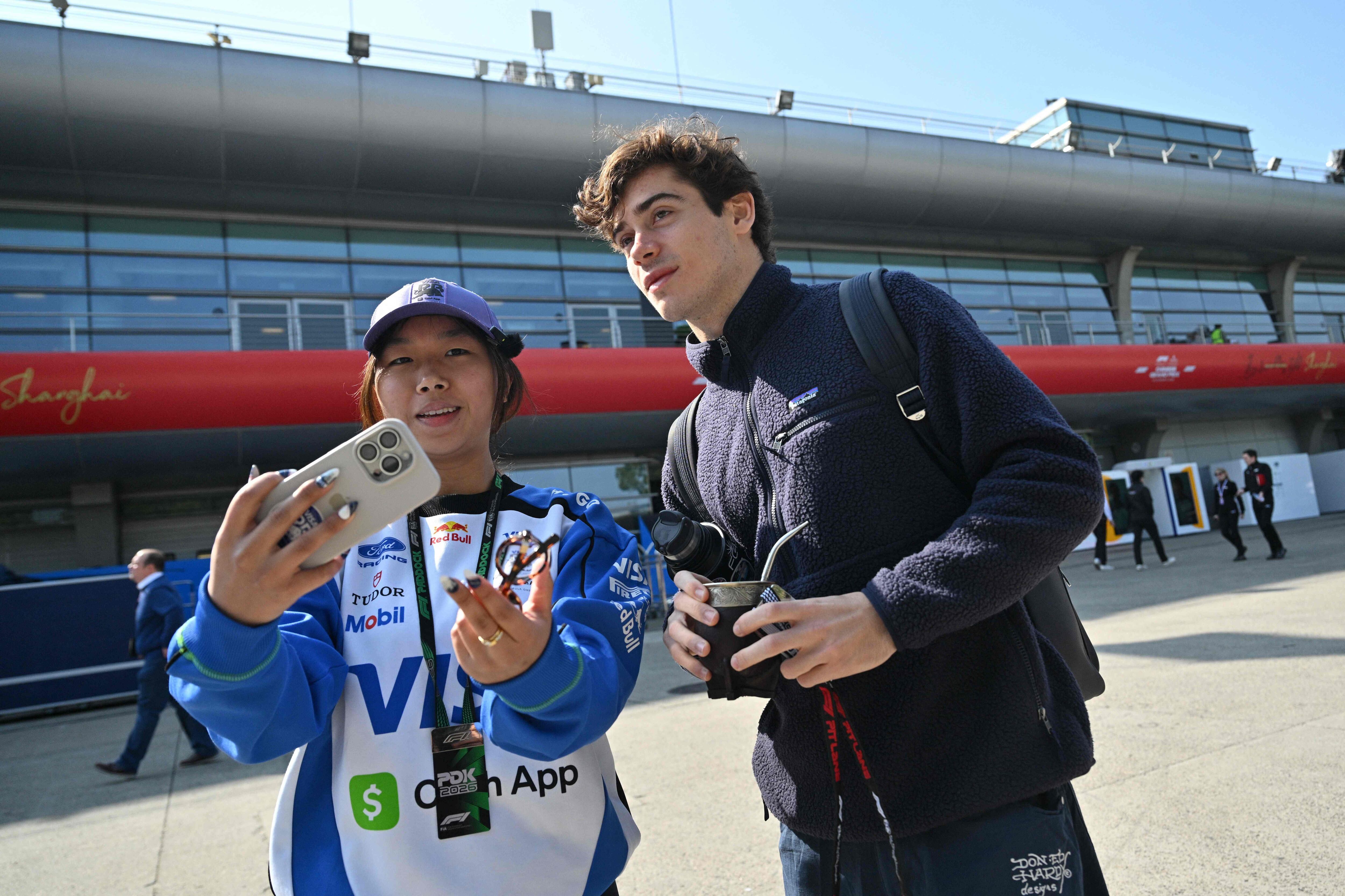 Franco Colapinto se presta a una foto con una auxiliar en el paddock de Shanghái; el piloto argentino suele ser foco de atención.