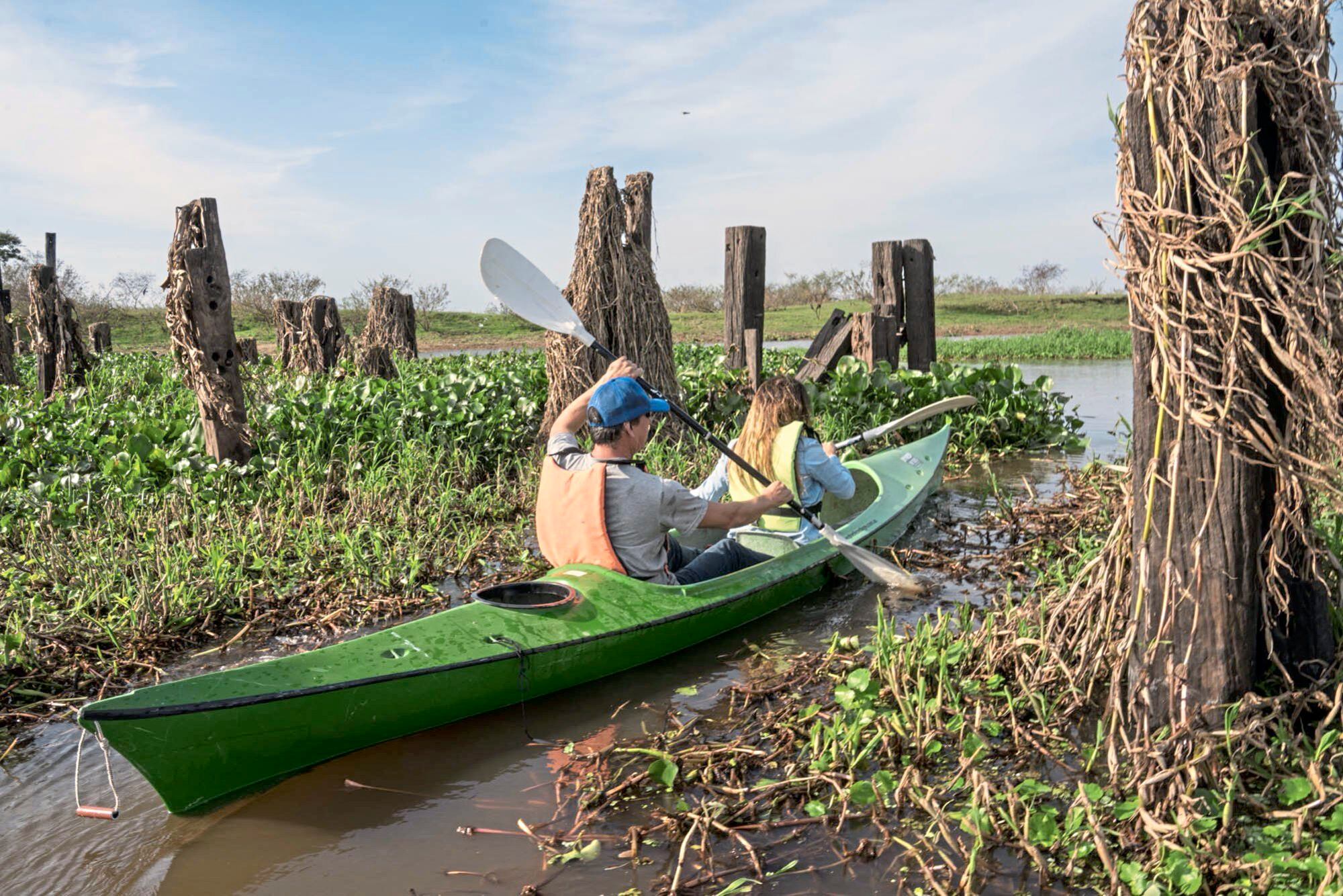 Las ruinas de un antiguo puente de La Forestal atraviesan parte del río Parana Miní, que se puede recorrer en kayak o lancha