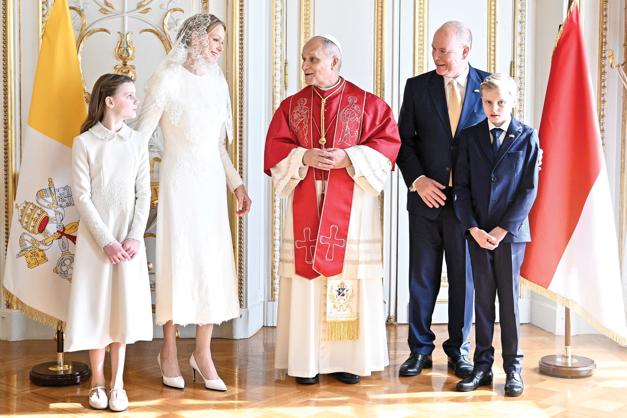 El Papa, en el Palacio de Mónaco, junto a
Sus Altezas Serenísimas y sus hijos. Charlene llevó
un diseño midi con bordados de Elie Saab que
complementó con una mantilla de encaje y Gabriella
optó por un vestido de manga larga con cuello bebé
y encaje floral. Los hombres, en tanto, vistieron
trajes azules decorados con pequeños broches de las
banderas del principado y del Vaticano