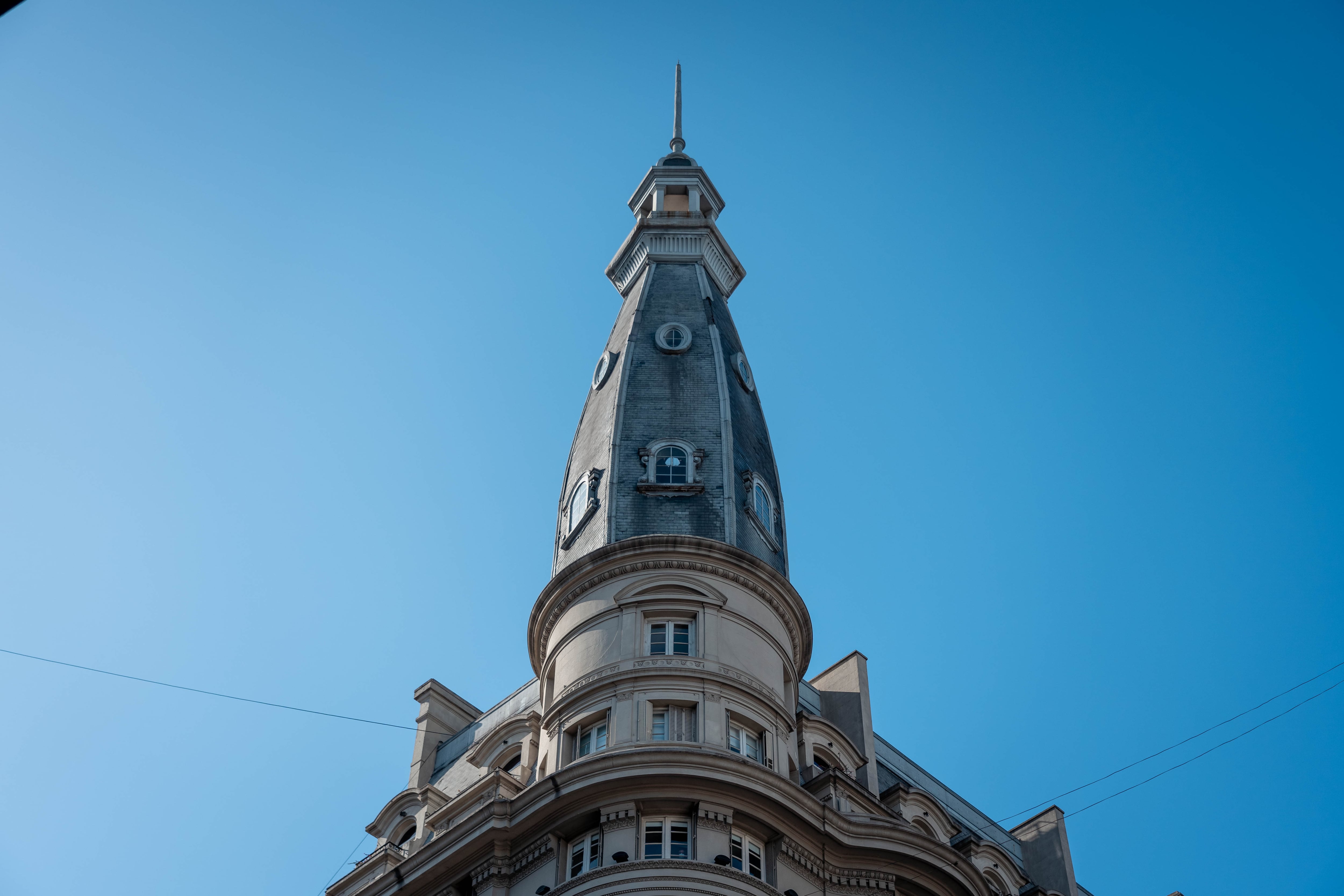 Recientemente restaurada, la cúpula incluye el cupulín y el pararrayos, y está flanqueada por dos mansardas recubiertas con tejas de pizarras ornamentadas con complementos en zinc