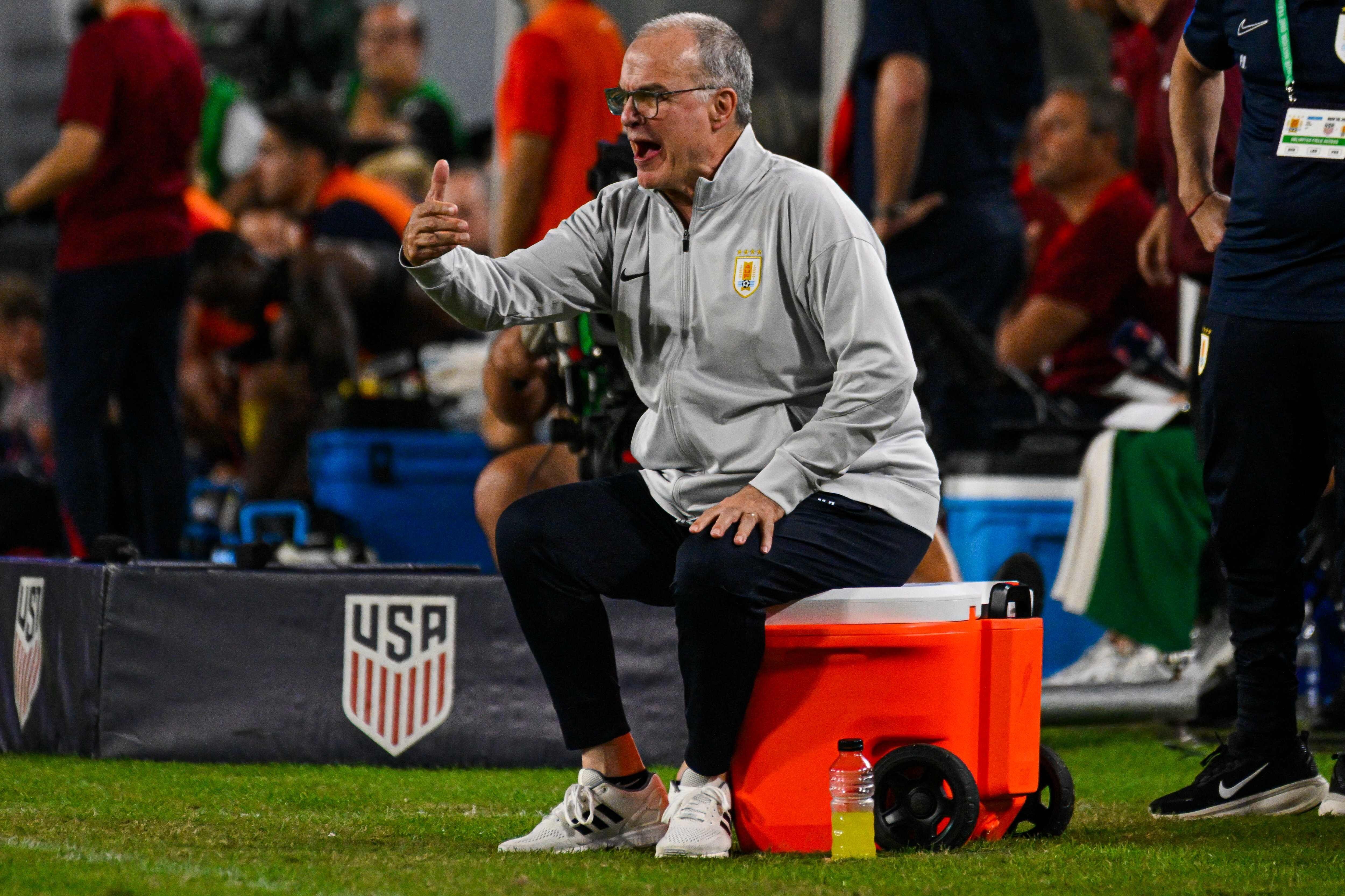 Clásica postura de Bielsa, a puro grito y sentado sobre una heladera al borde del campo de juego.