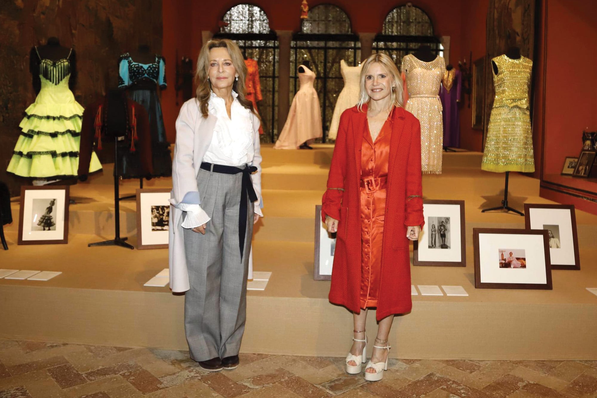 Eugenia Martínez de Irujo junto a la historiadora de arte Cristina Carrillo de Albornoz, con quien realizó la curaduría de la muestra, posa delante de algunos de los trajes que se exhiben