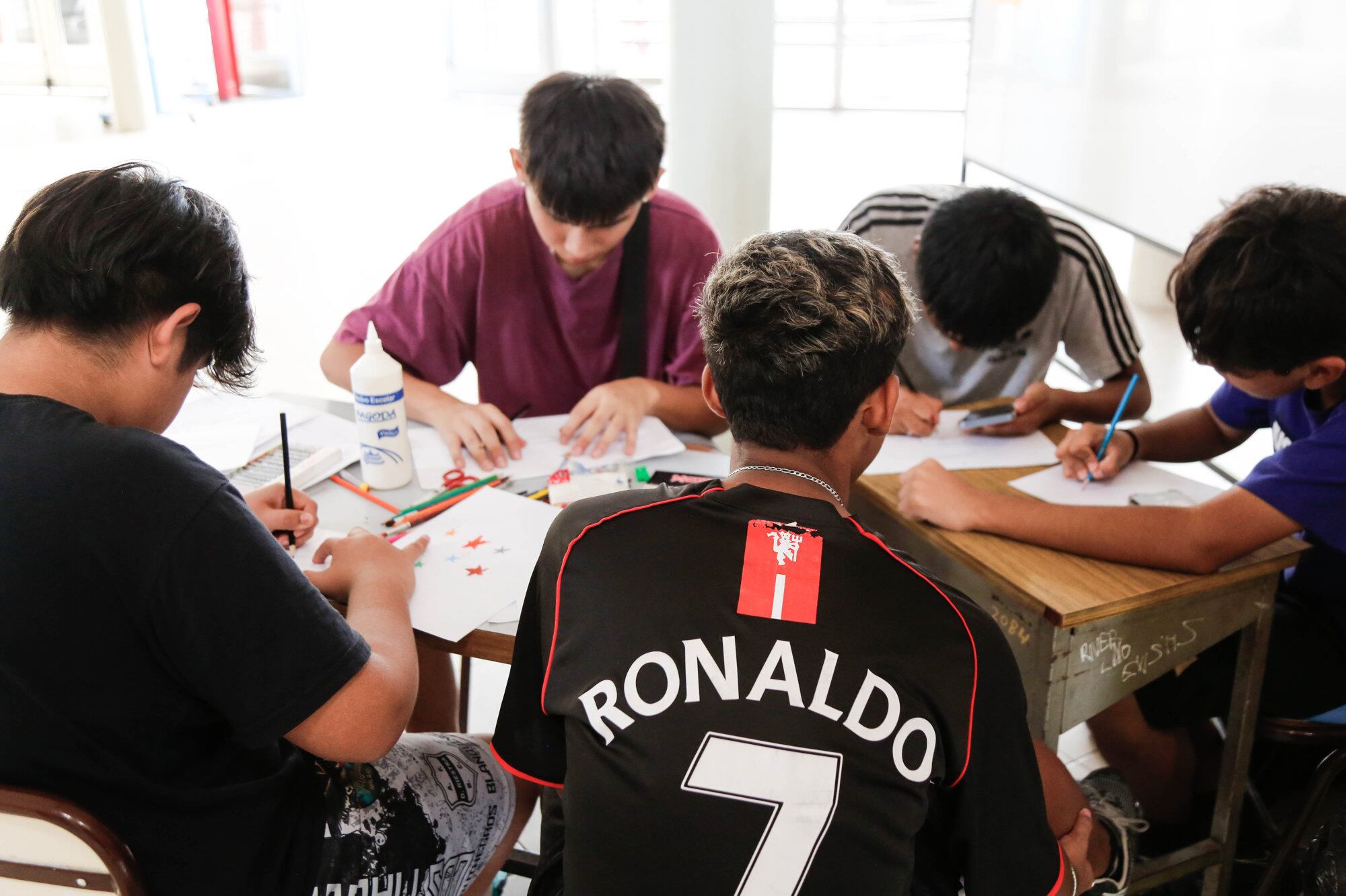 Un grupo de chicos dibujan en la Técnica N°7 de Parque Patricios, donde los sábados funciona como club de jóvenes