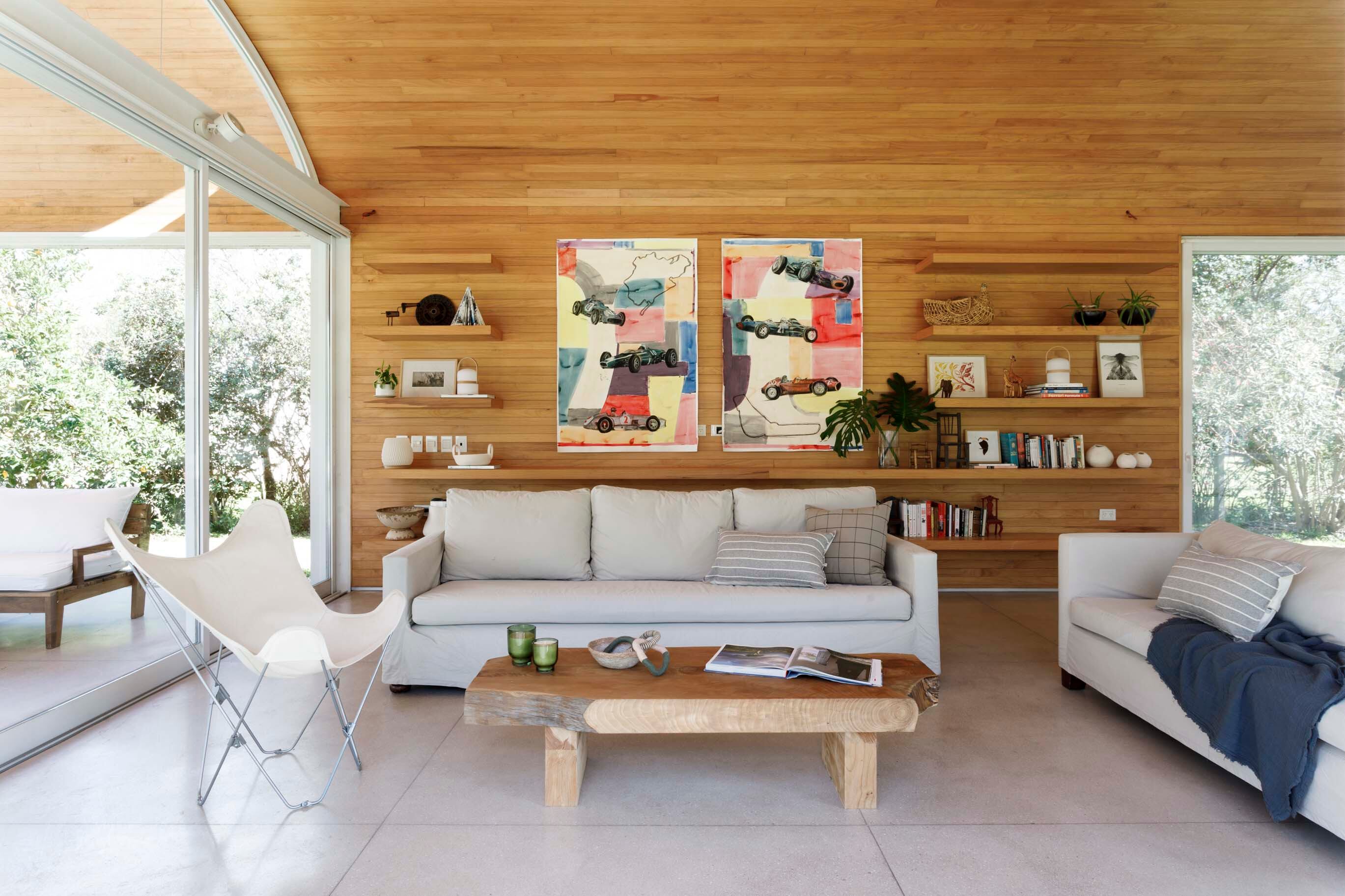 Sillones (Tapicería Do Braz), silla ‘BKF’ (Morph) y mesa baja de ciprés (Carpintería Sebastián Fernández Lando). Como contrapunto a la madera, coloridas obras en fieltro (Virginia Caorsi Resúa).