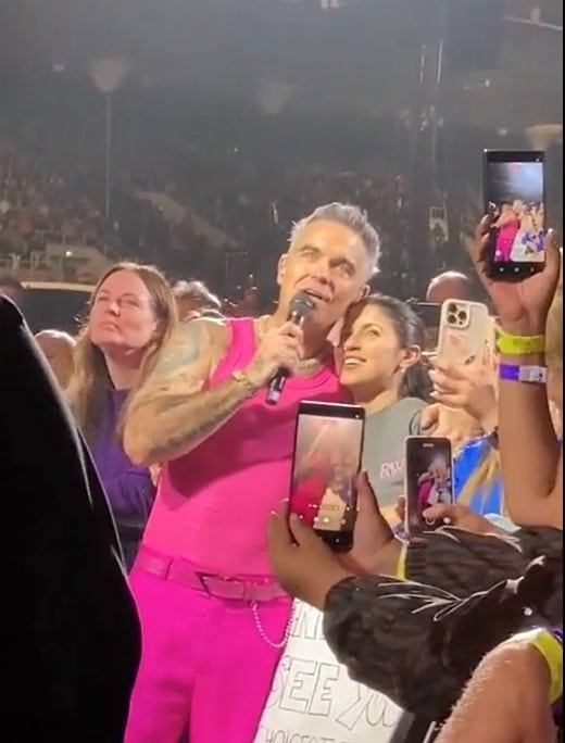 Robbie Williams junto a Camila, la fanática argentina a la que el cantante le prometió regresar a nuestro país