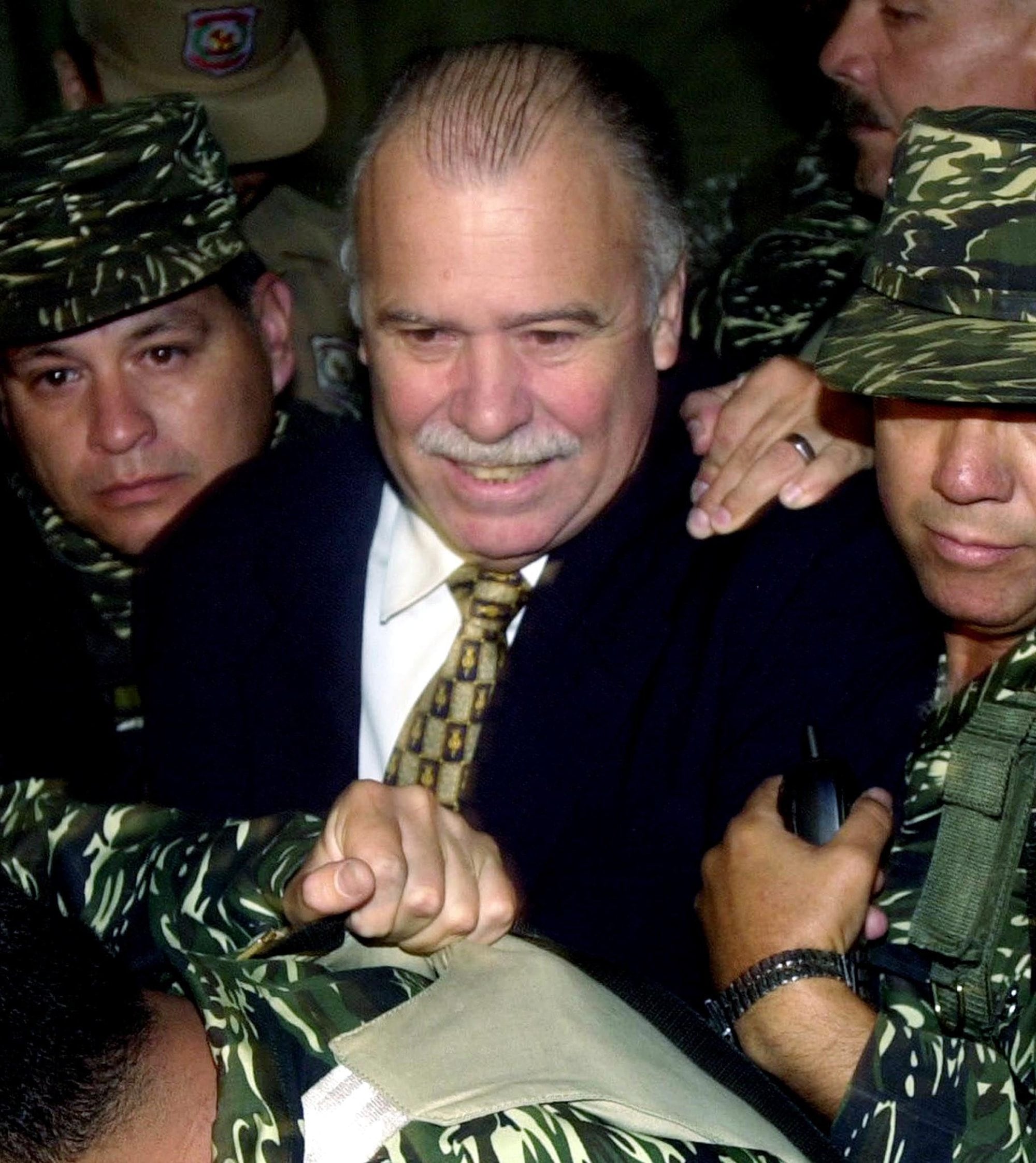 El expresidente paraguayo Raúl Cubas Grau es llevado a una corte en Asunción, en 2002