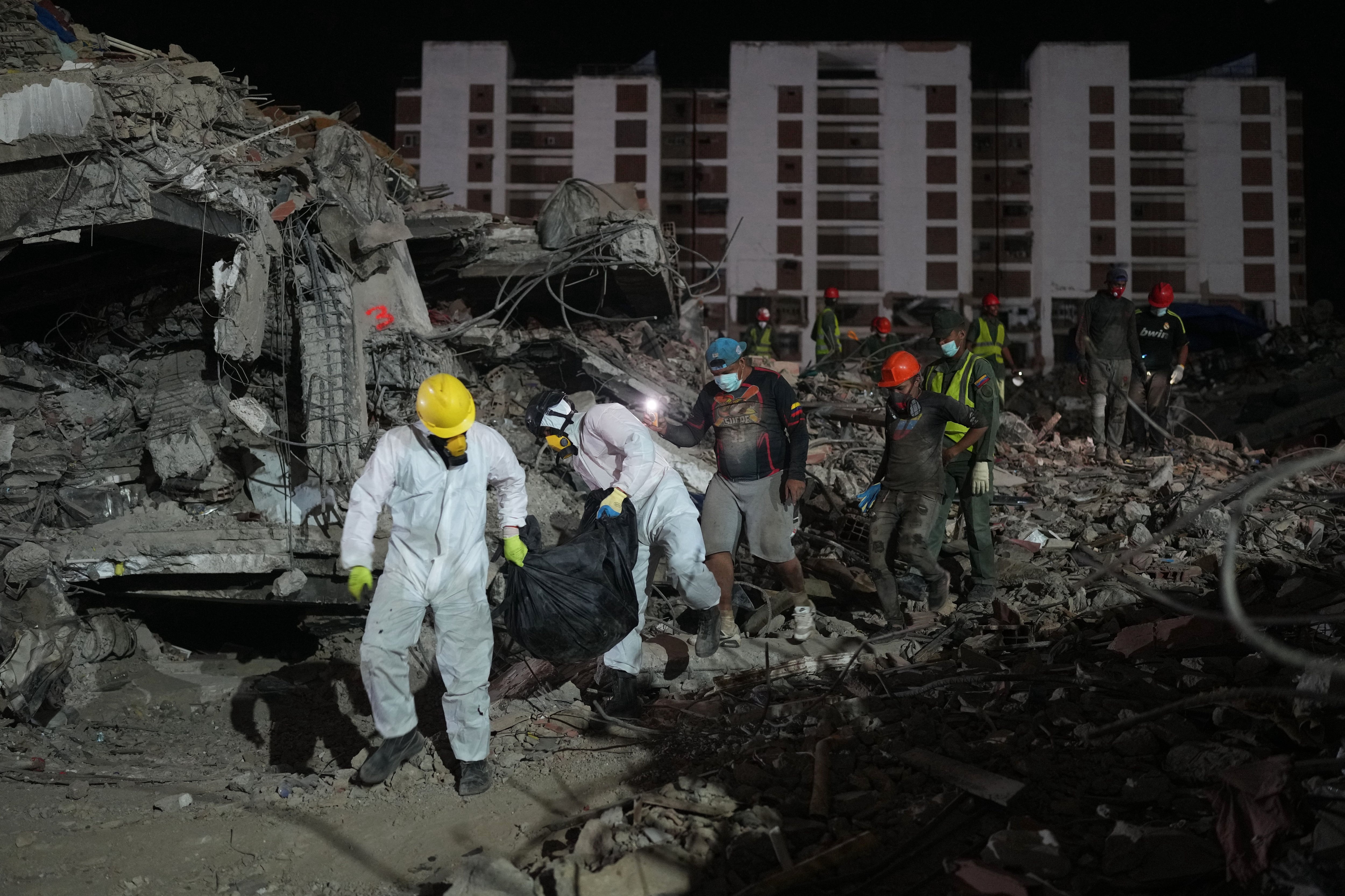 Unas personas transportan un cadáver rescatado de un edificio que se derrumbó a causa de los terremotos en La Guaira, Venezuela, el jueves 30 de julio de 2026. (Foto AP/Ariana Cubillos)