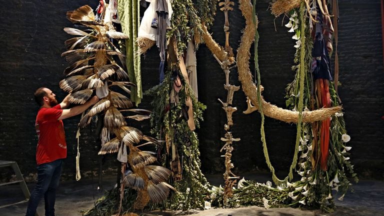 El artista rosarino Carlos Herrera con su instalación realizada con plantas, ropa y huesos en arteba Focus 2017
