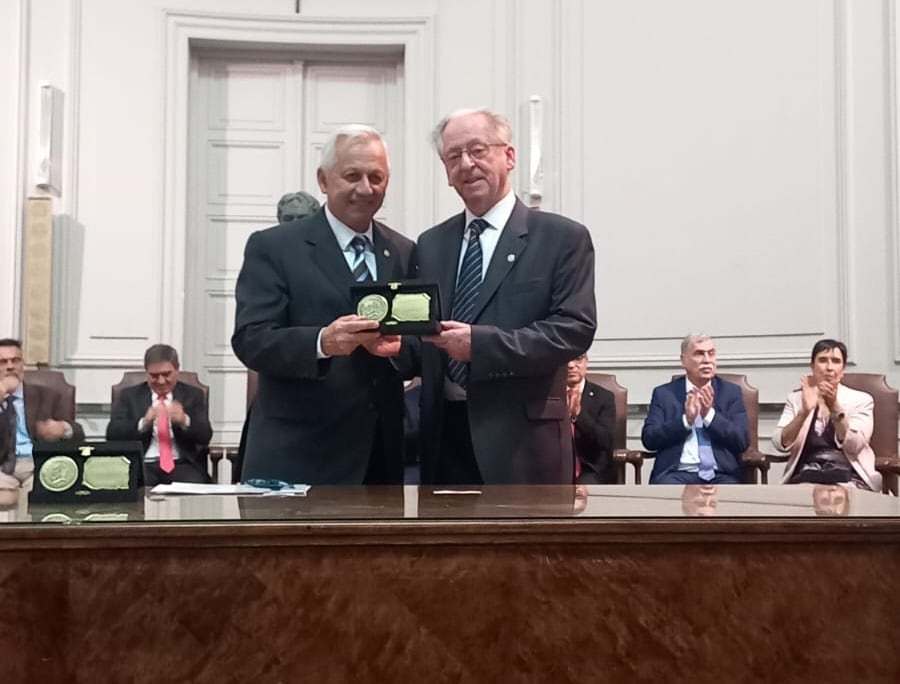 El cirujano infantil Cristóbal Papendieck (dreecha), al recibir el premio del decano de la Facultad de Ciencias Médicas de la Universidad del Salvador, Daniel Martínez.