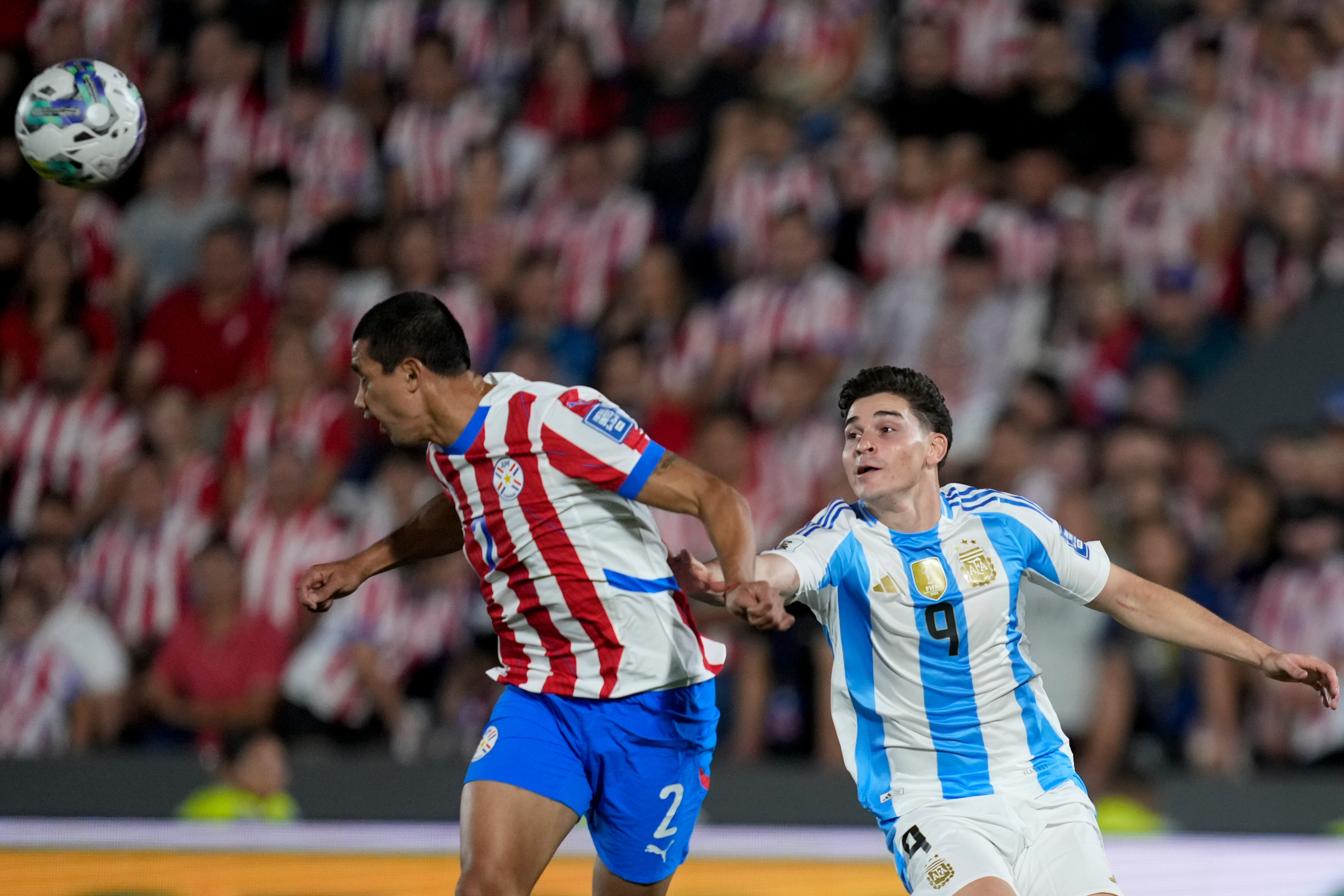 Julián Álvarez disputa la pelota con Gustavo Velázquez