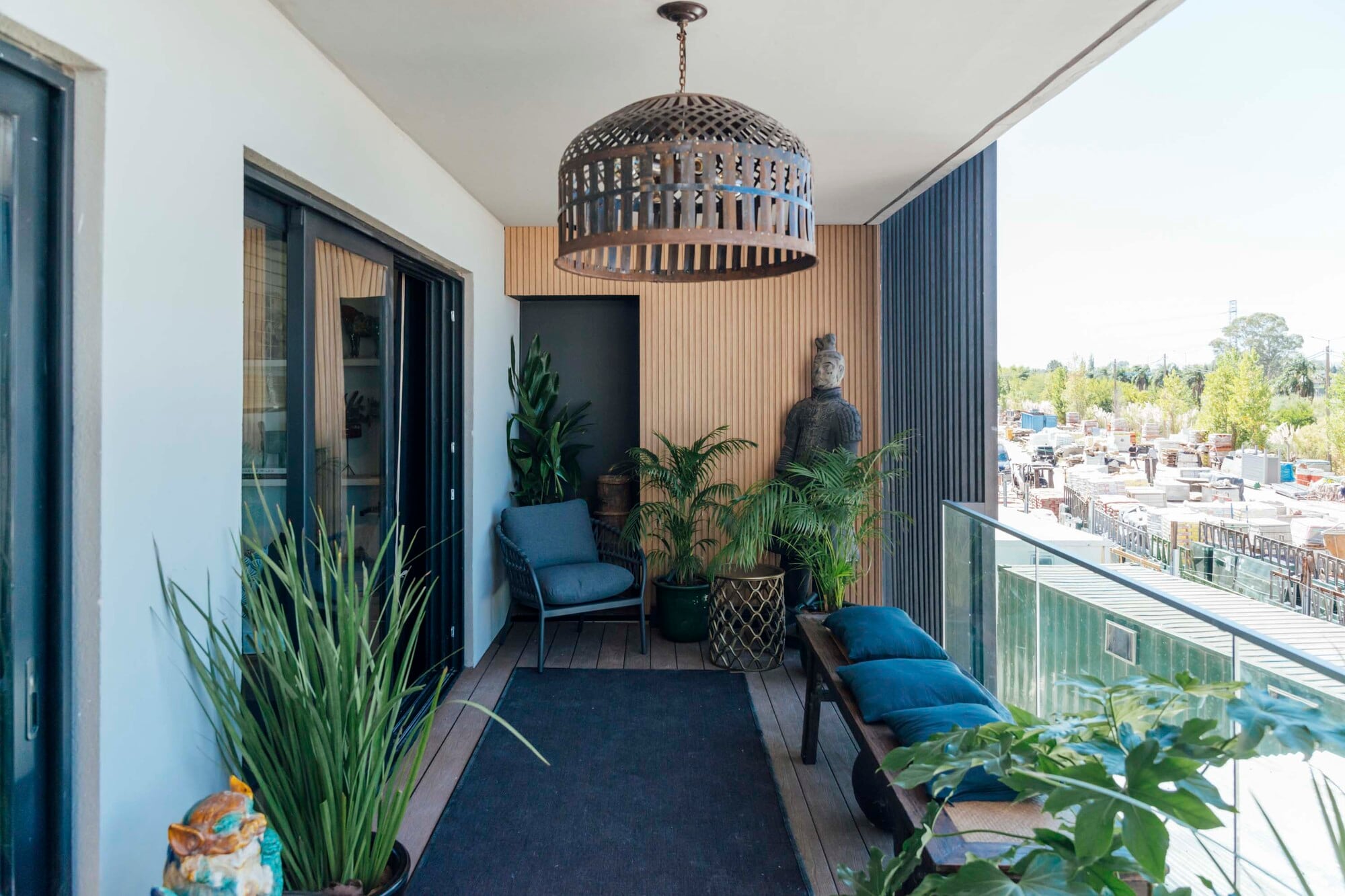 La presencia de azul en este balcón con propuesta de sillón, almohadones y alfombra