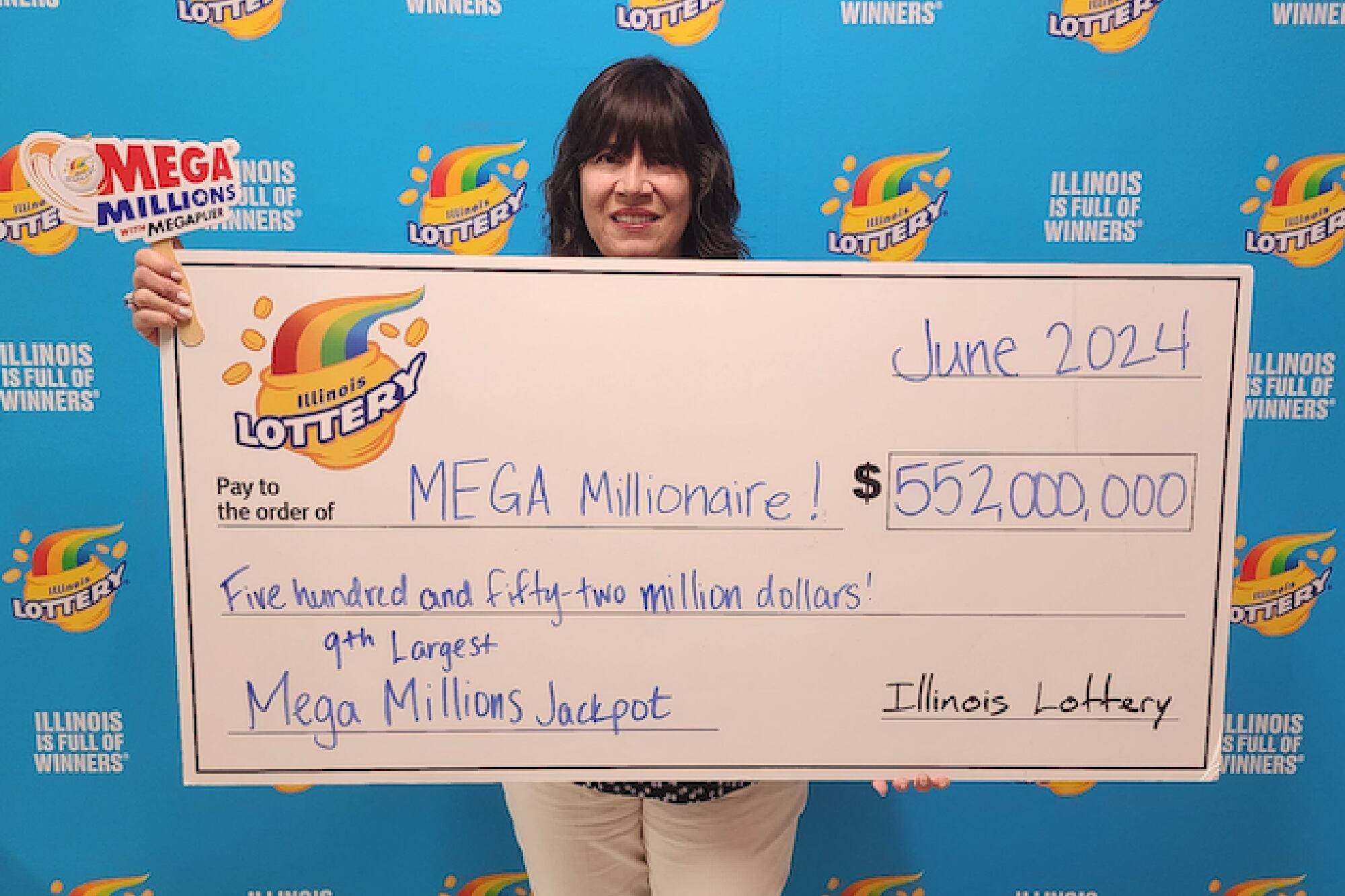 La supervisora del Centro de Premios Des Plaines de la Lotería de Illinois, Kathy, posó con el cheque, debido a que el ganador de Mega Millions decidió permanecer en el anonimato