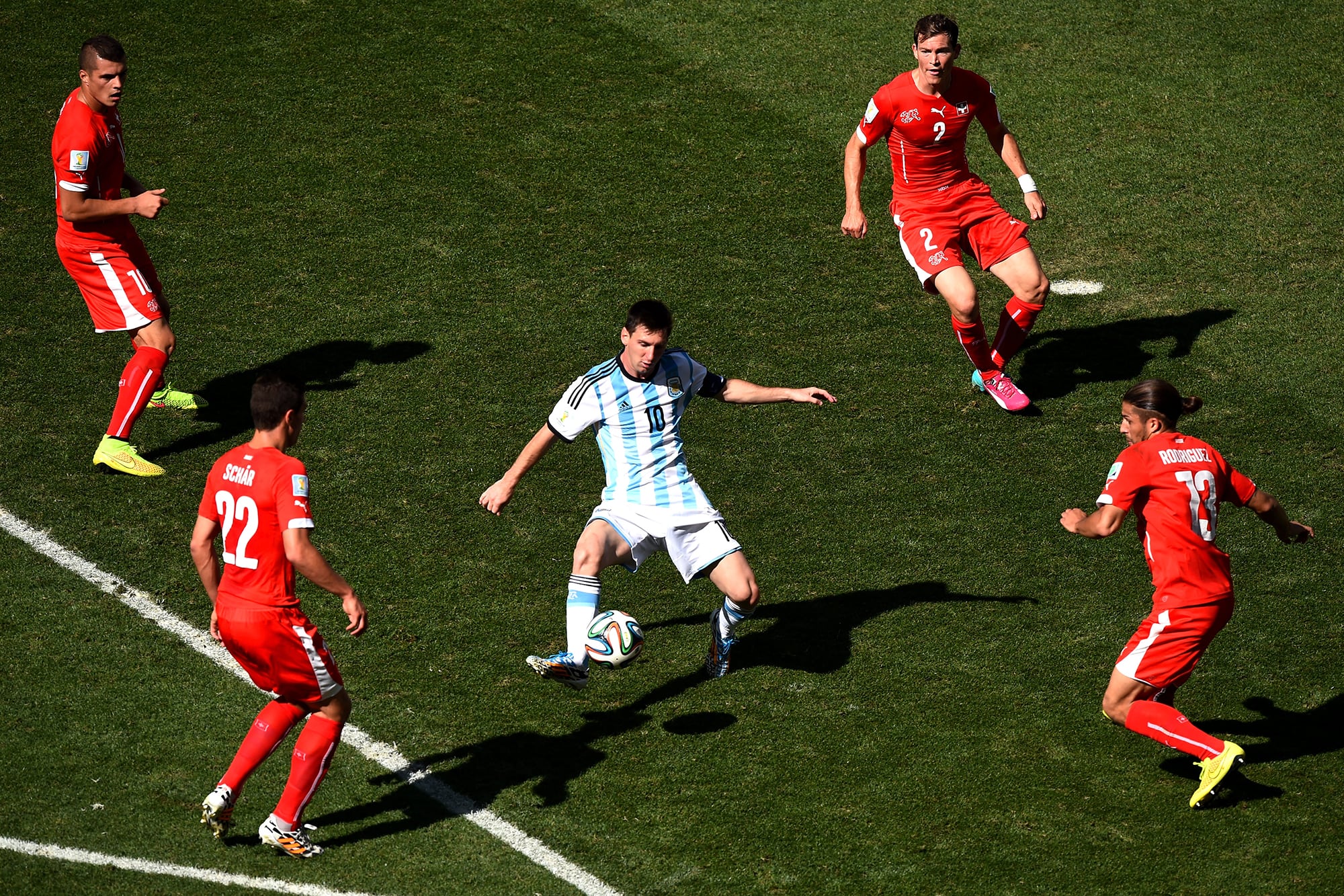 Lionel Messi rodeado por Granit Xhaka (izquierda arriba) y Ricardo Rodríguez (derecha abajo), además de Josip Drmic (derecha arriba) y Stephan Lichtsteiner (izquierda abajo), durante el partido entre la Argentina y Suiza en 2014