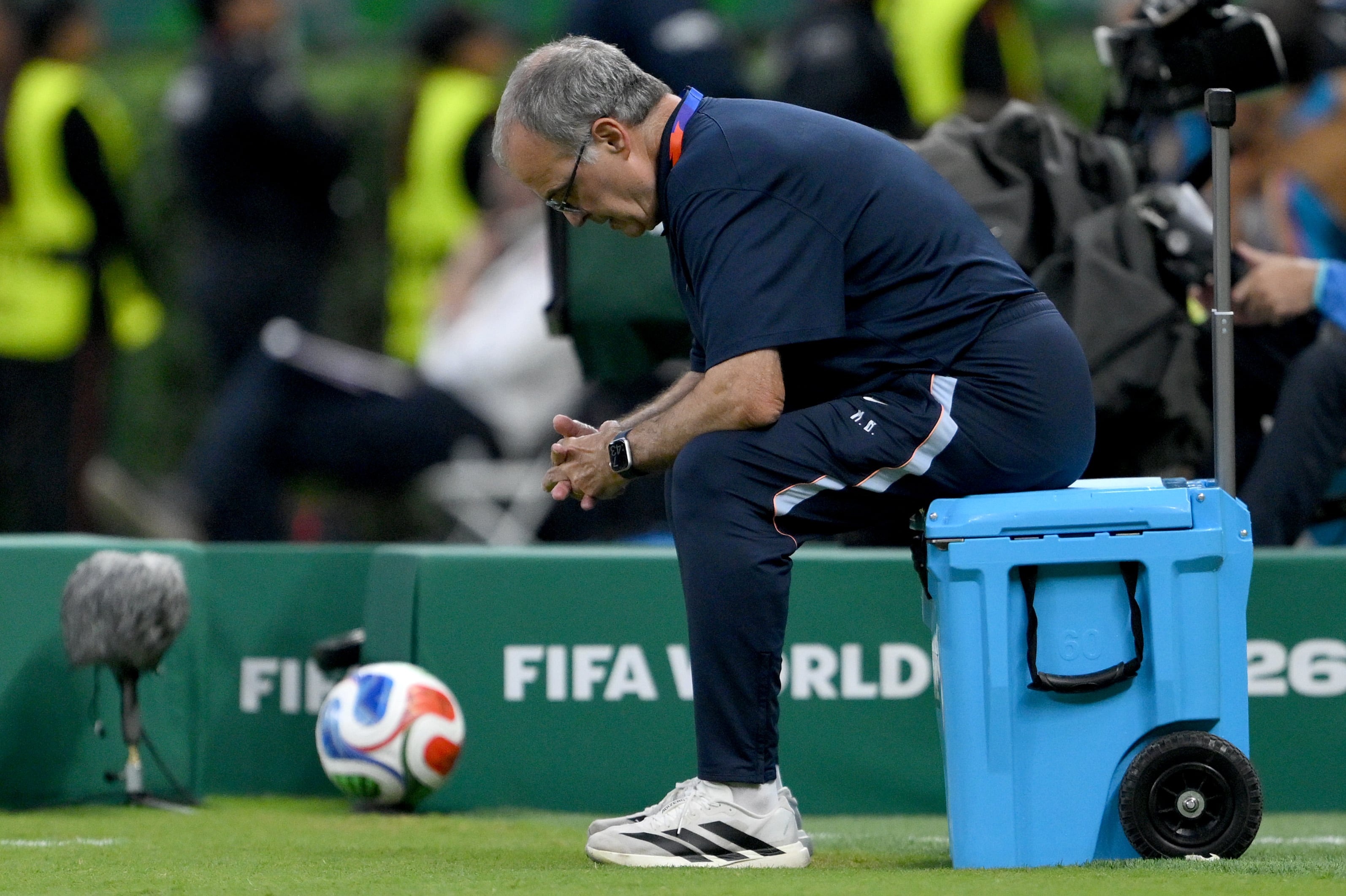 Típica pose de Bielsa durante un partido, sobre una heladerita; el rosarino se adjudicó la responsabilidad por la desazón uruguaya.