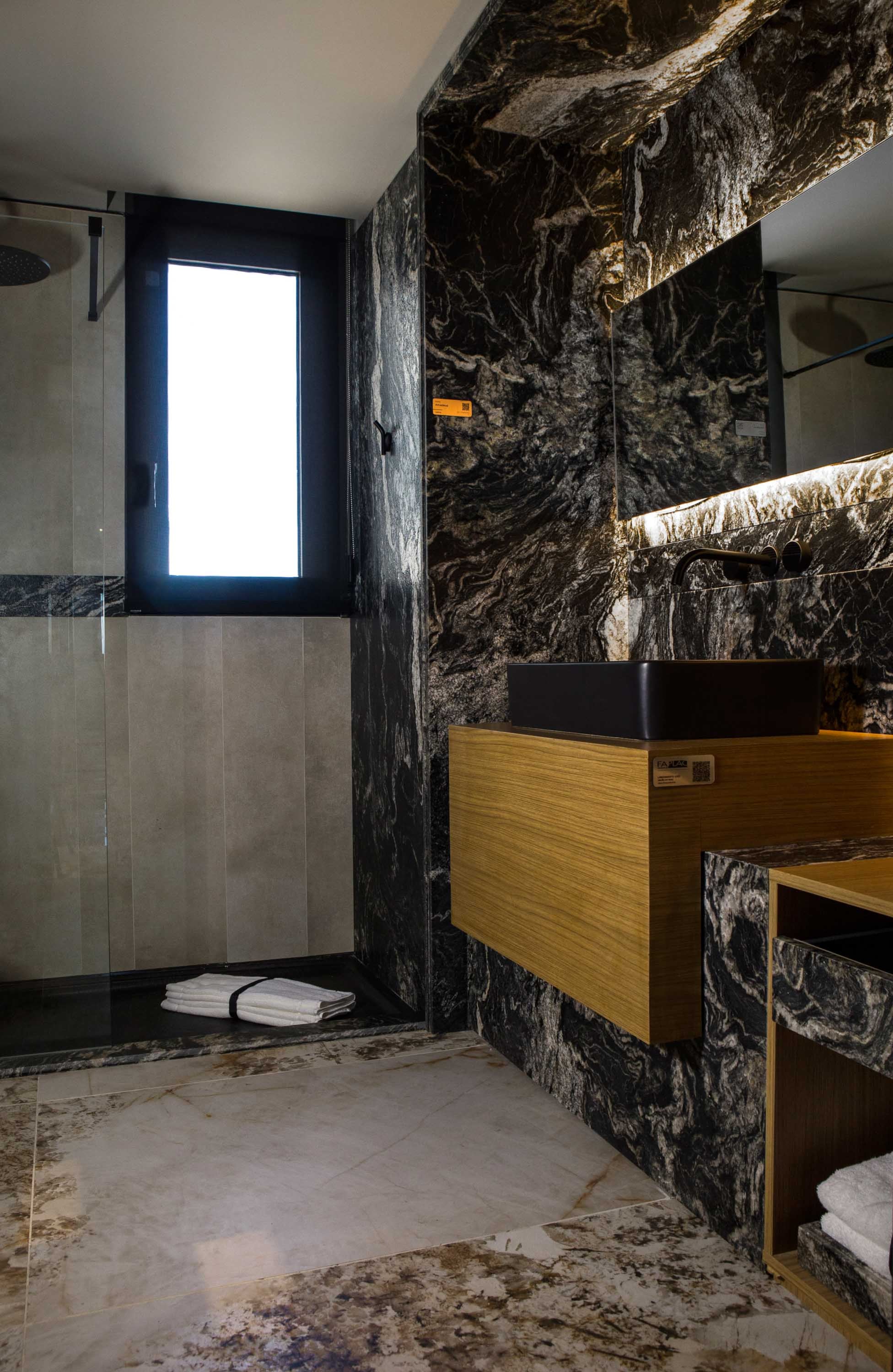 El piso del baño está revestido con la placa Fast Marfil (San Lorenzo Design). Mampara (Shawer). Bacha 'Country Baja' (Ferrum) y grifería 'Grip' en Negro Mate (FV).