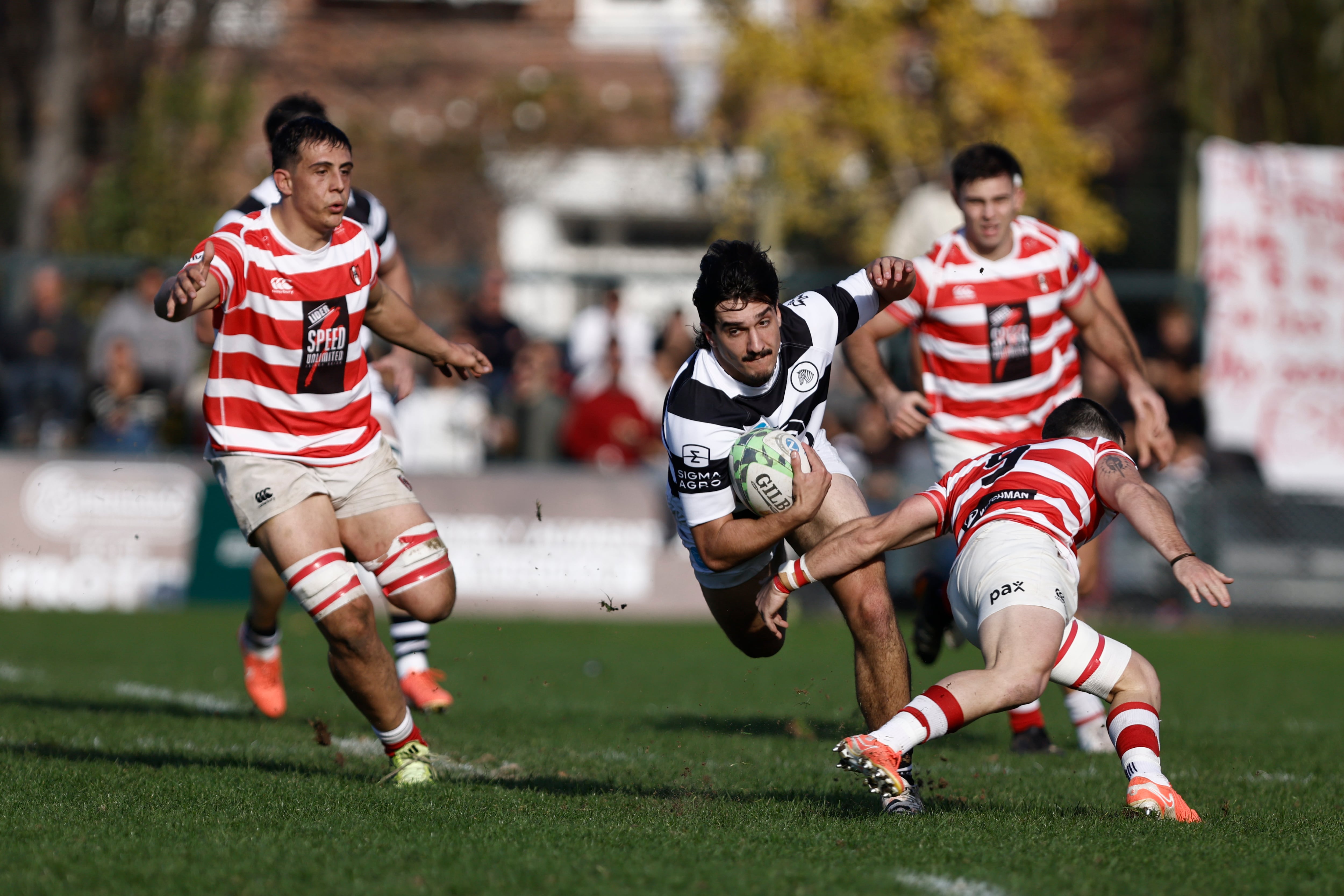 Tomás Phelan escapa de un tackle pasado de Rocco Testoni; atrás, Sebastián Fauve e Ignacio Cubilla.