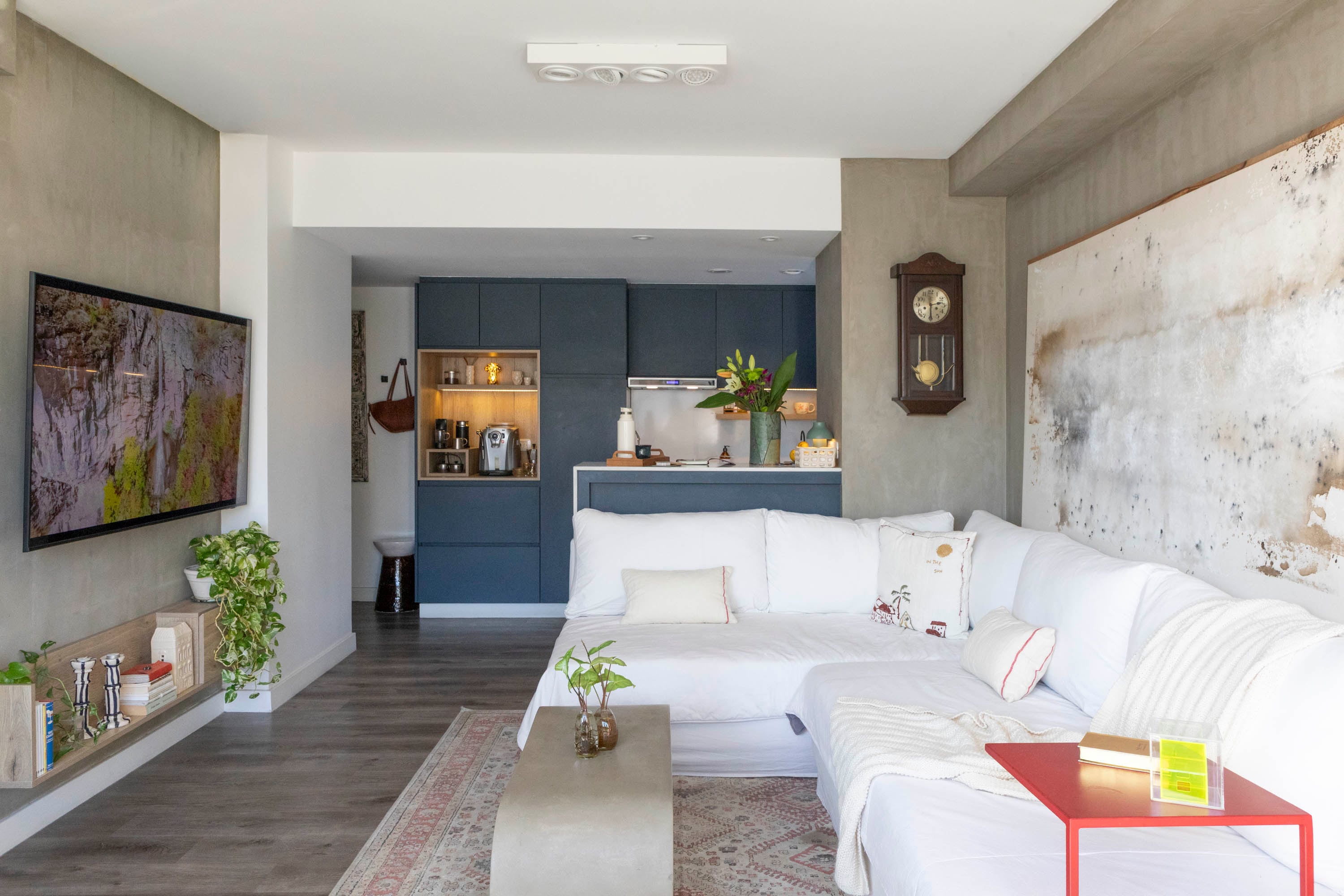 Pared con acabado en hormigón visto (Quimtex Llana) y obra de Martín Enricci. Sofá modular con funda en tussor (Casa Ibra). Espectacular mesa ratona de hormigón armado (Estilo Ribera).