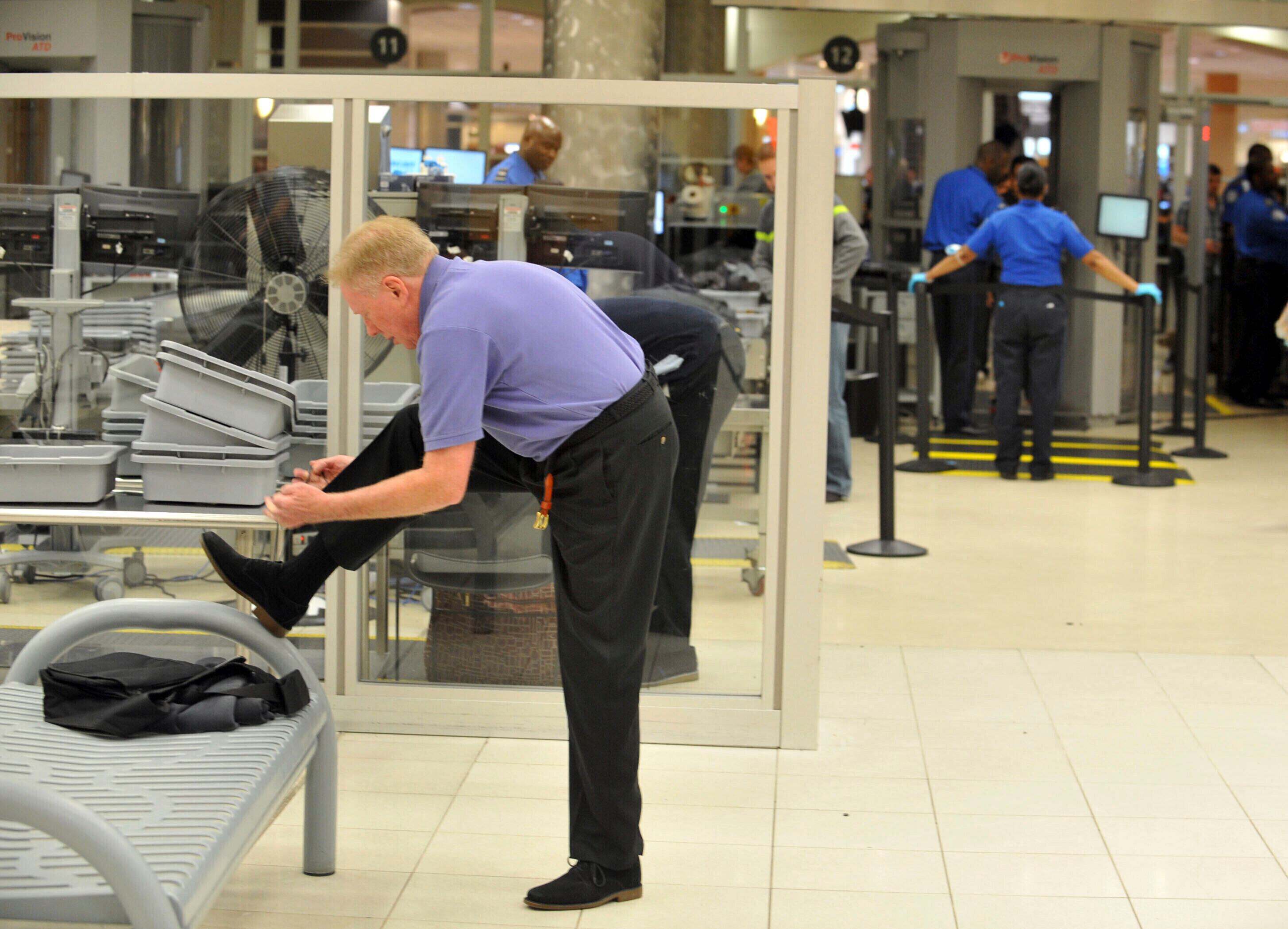 Un viajero se quita los zapatos en el Aeropuerto Hartsfield-Jackson de Atlanta el 15 de enero del 2014. (Kent D. Johnson/Atlanta Journal-Constitution via AP)