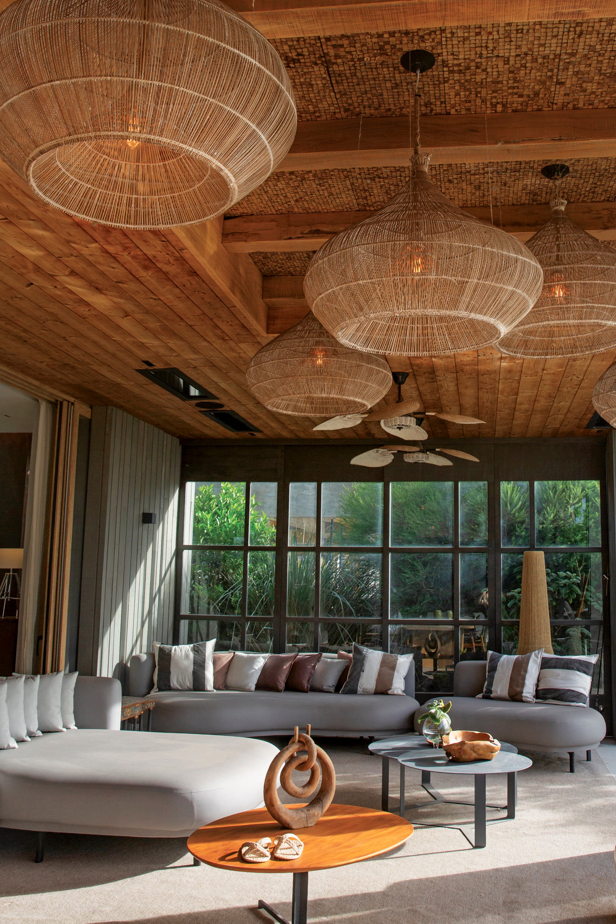 Los comodísimos sillones de la galería invitan a la charla relajada. “Me gusta sumar materiales que te relajen, como la esterilla, la rafia o el yute. Si bien son más rústicos, en una casa sólida quedan bien”, afirma Vero