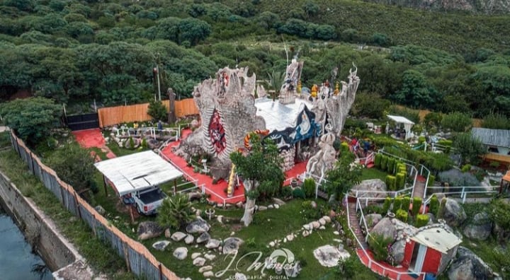 Los elevados cerros del cordón de Velasco enmarcan la extraña construcción, rodeada de los canales de riego que construyeron los picapedreros hace más de cien años.