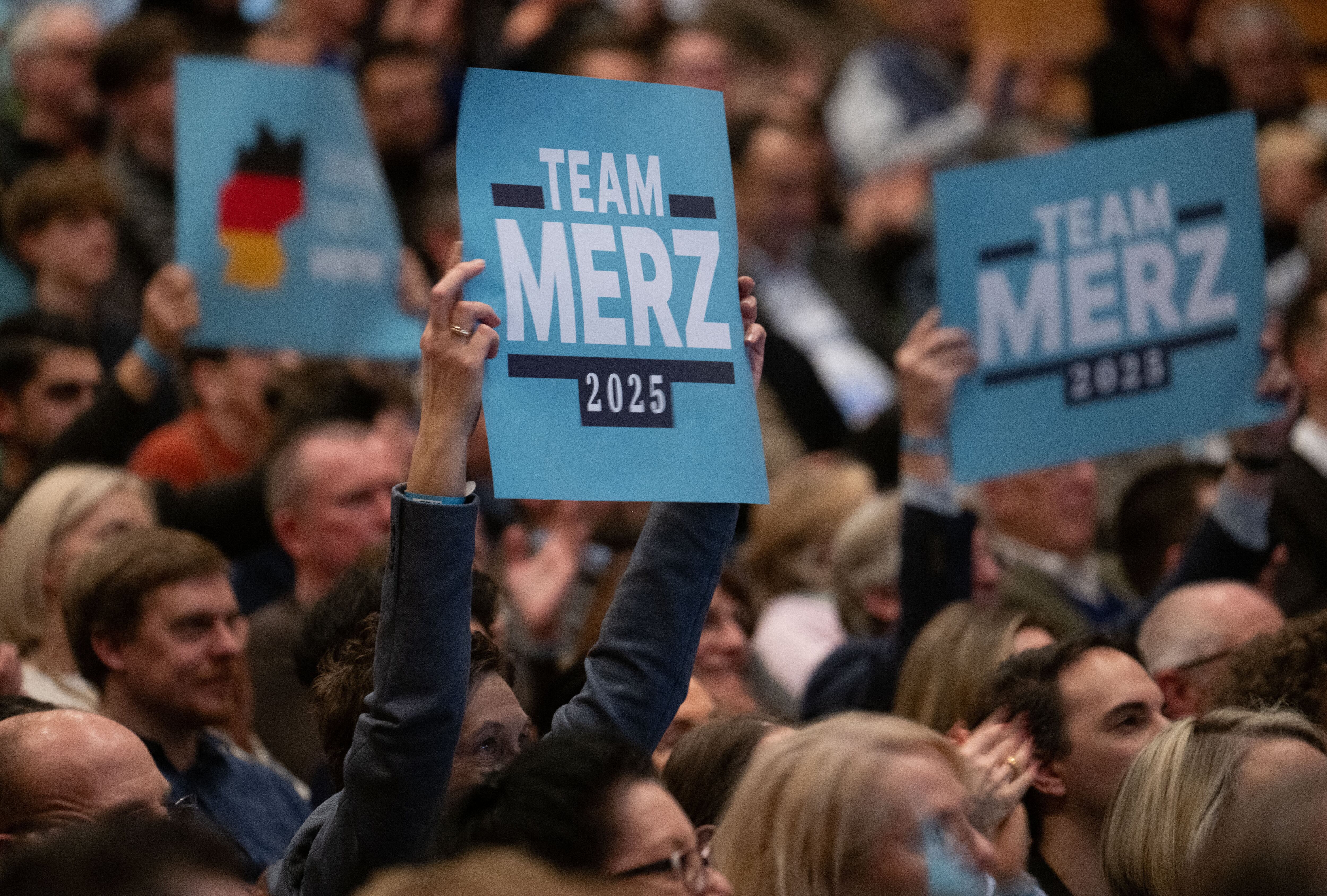 Los asistentes sostienen carteles que dicen