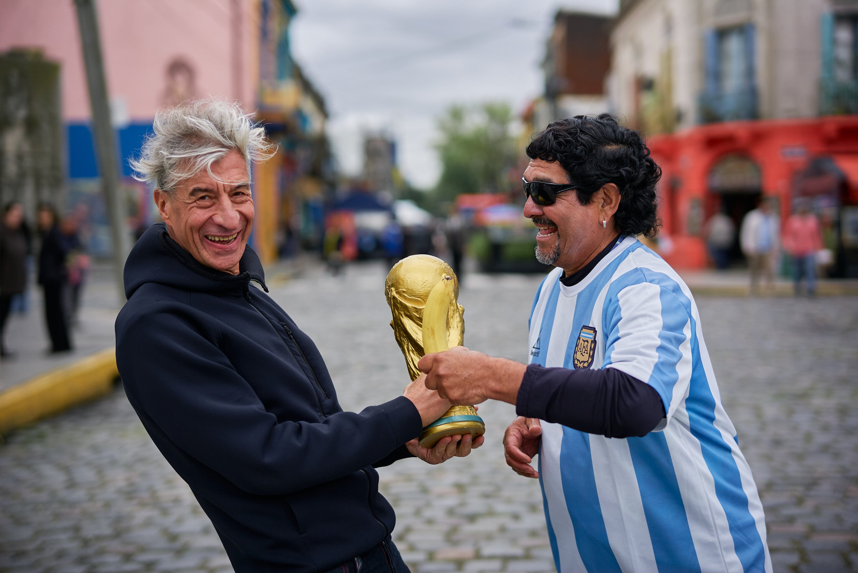 El doble de Maradona le entrega una réplica de la Copa del Mundo a Cattelan en Caminito