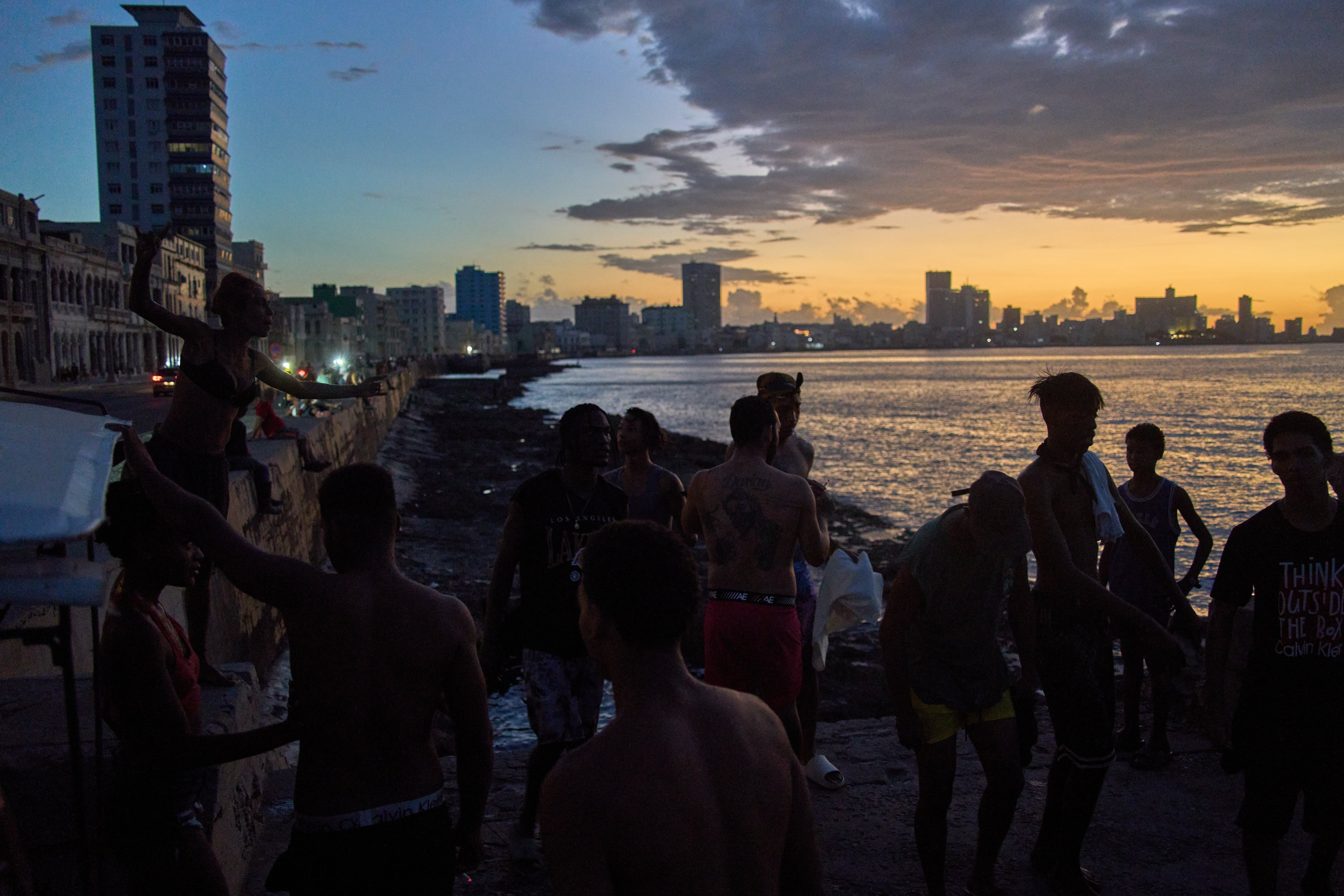La gente observa la puesta de sol desde el Malecón durante un apagón en La Habana, el lunes 16 de marzo de 2026. (Foto AP/Ramón Espinosa)