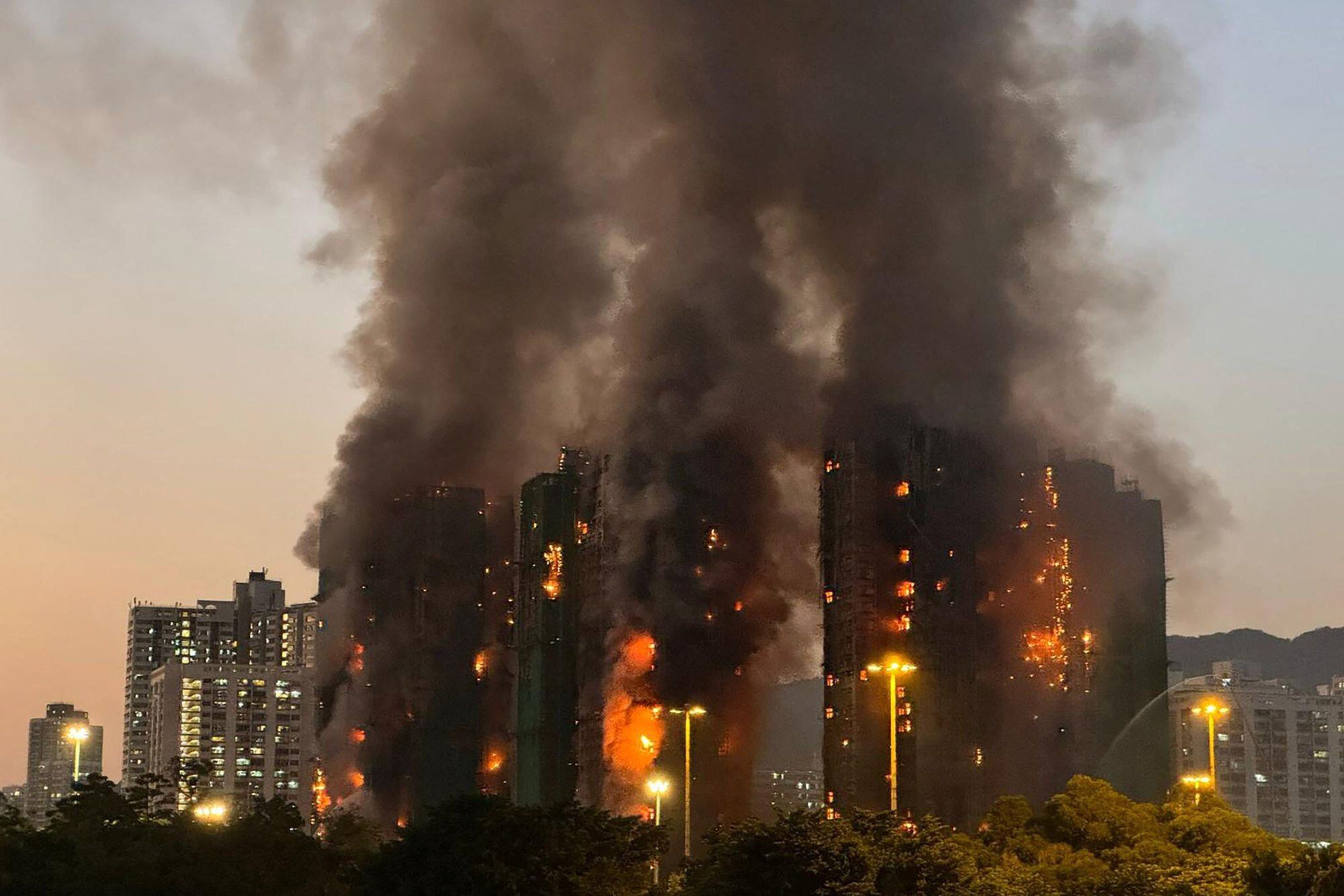 Una densa columna de humo y llamas se eleva mientras un gran incendio envuelve varios bloques de apartamentos en Wang Fuk Court, en el distrito de Tai Po, Hong Kong, el 26 de noviembre de