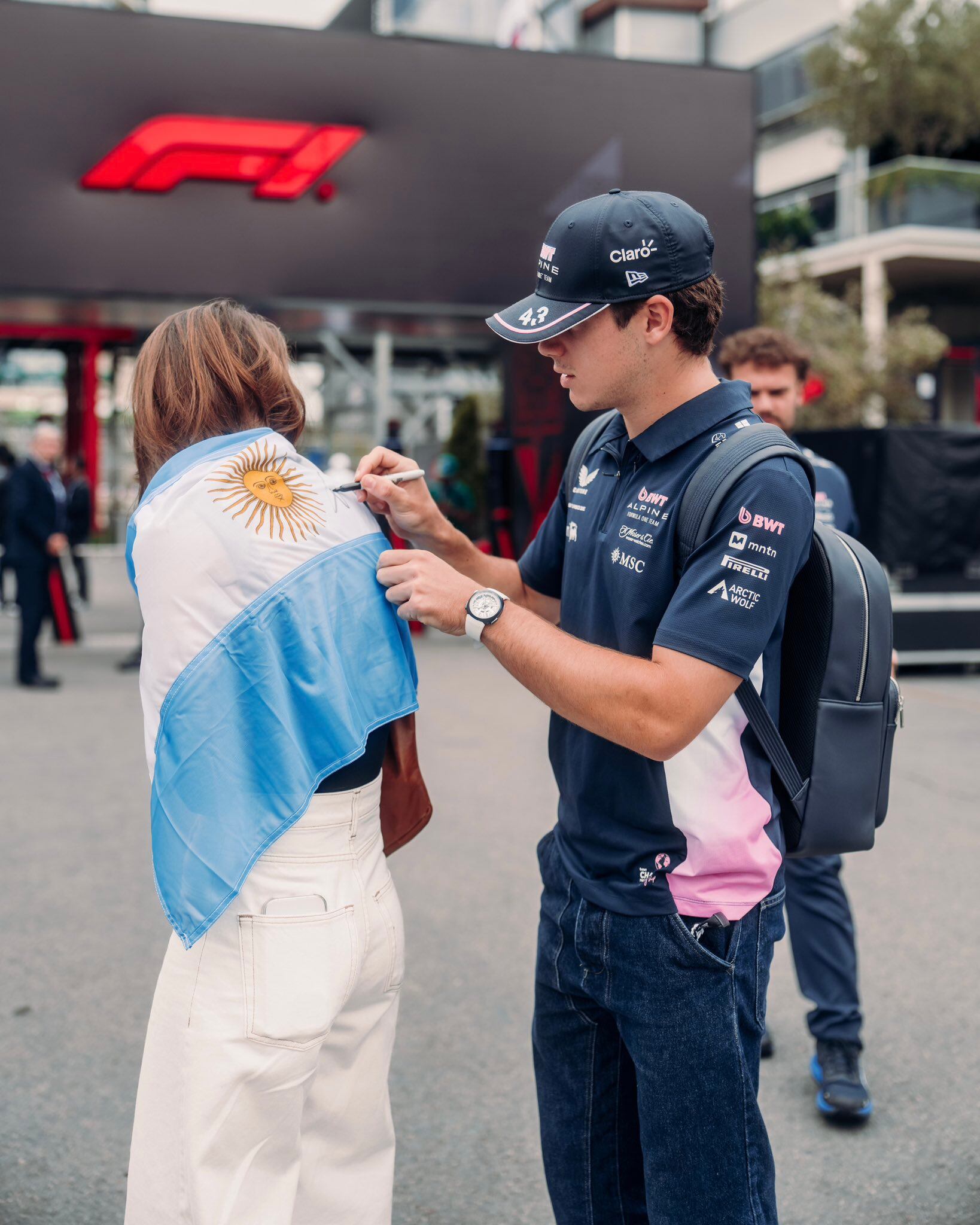 Colapinto firma la bandera de una fan antes de afrontar la primera práctica libre en Bakú